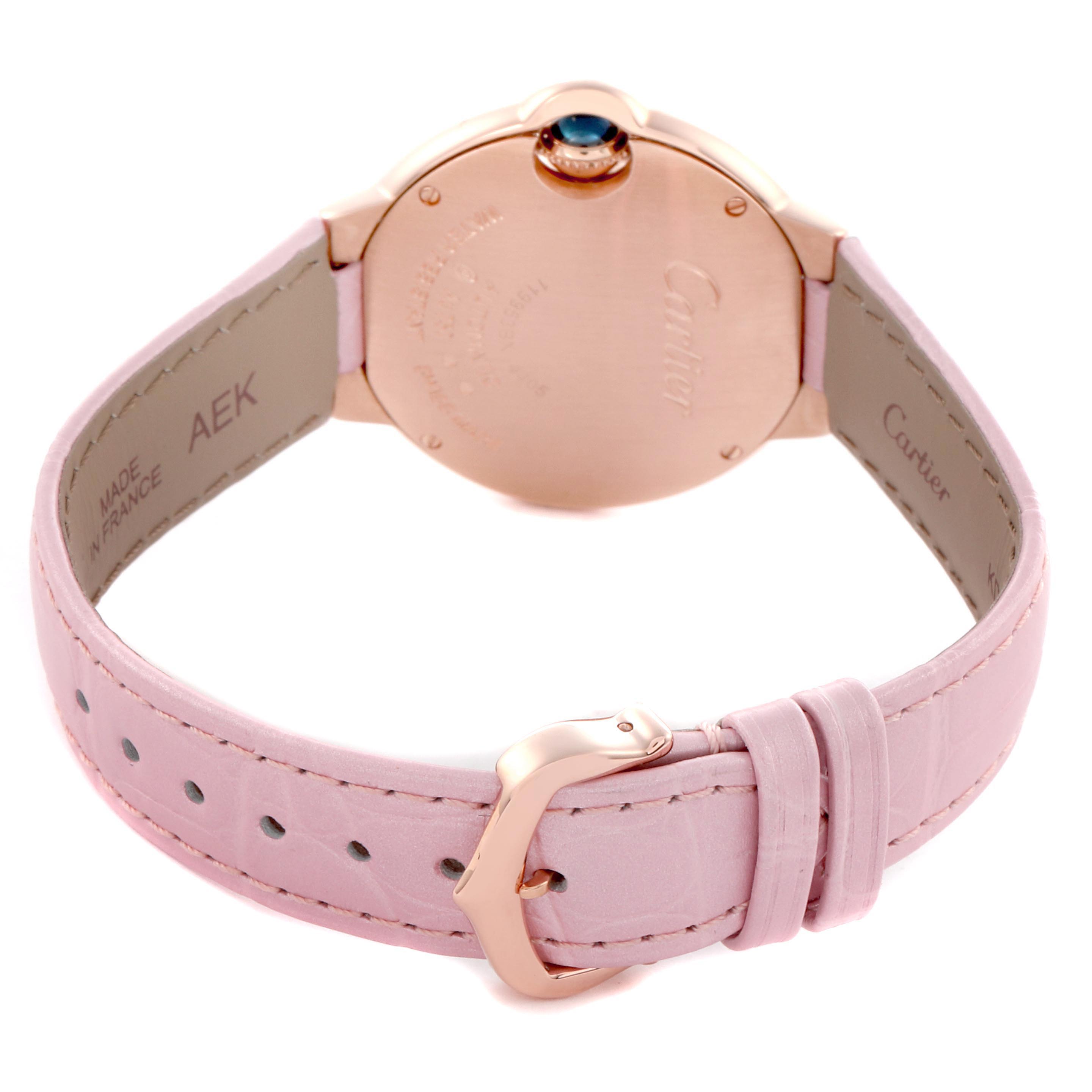 The image shows the Ballon Bleu by Cartier from the back, highlighting the caseback, crown, and pink strap with a buckle.