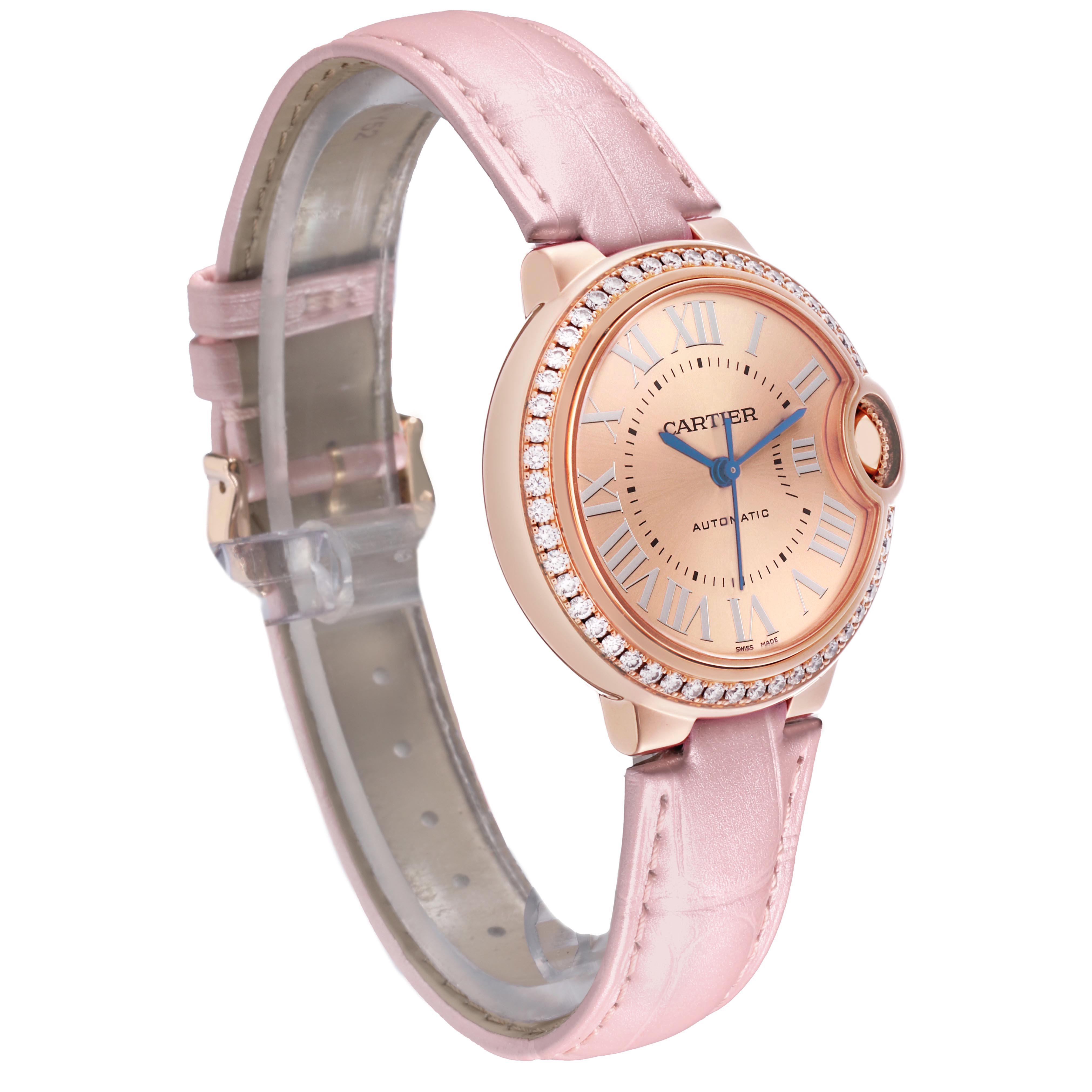 The Cartier Ballon Bleu WJBB0076 Women's Rose Gold Pink Dial watch is shown at an angled side view, highlighting its pink strap and diamond-studded bezel.