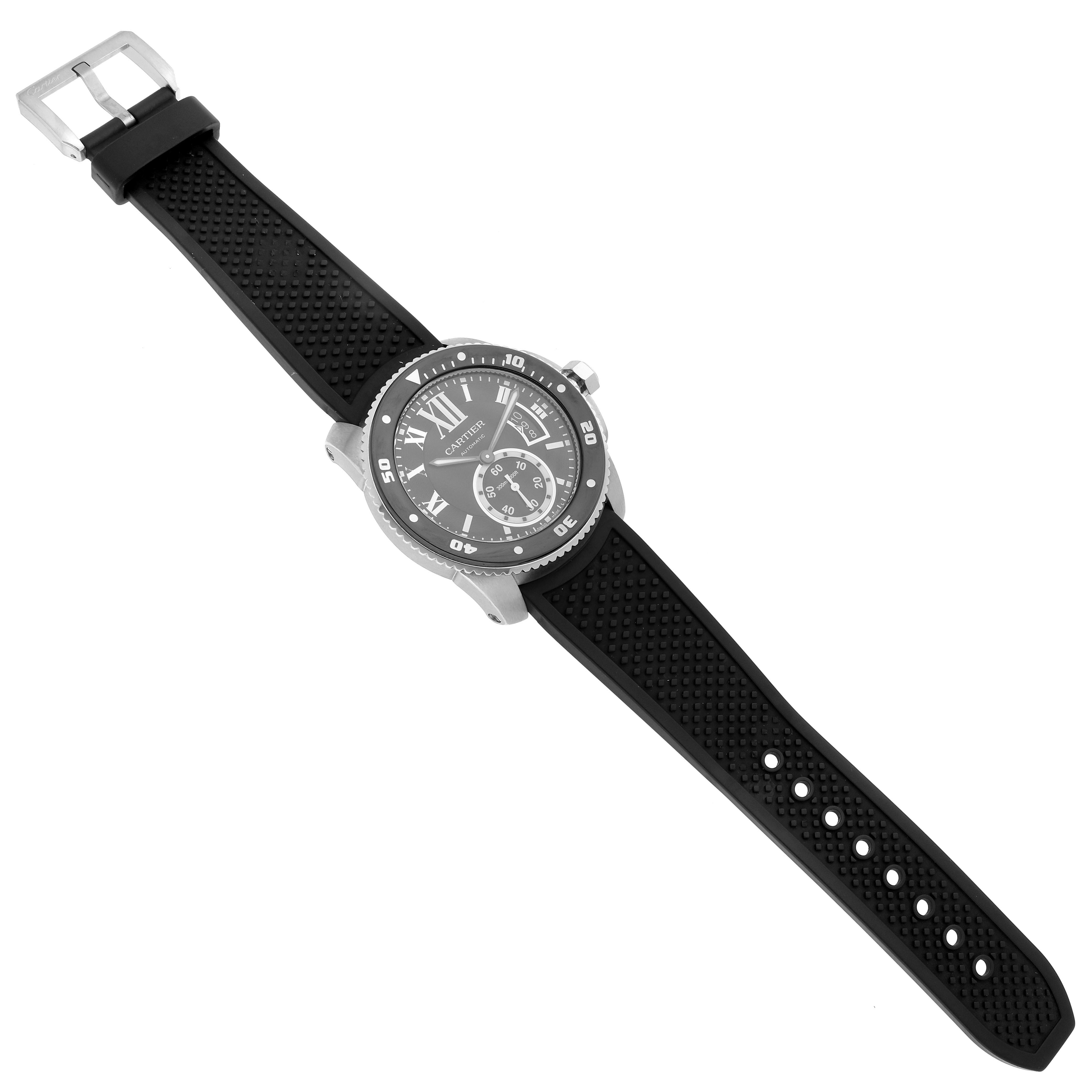 The Calibre de Cartier watch is shown from a top-down angle, displaying its face, bezel, and textured strap.