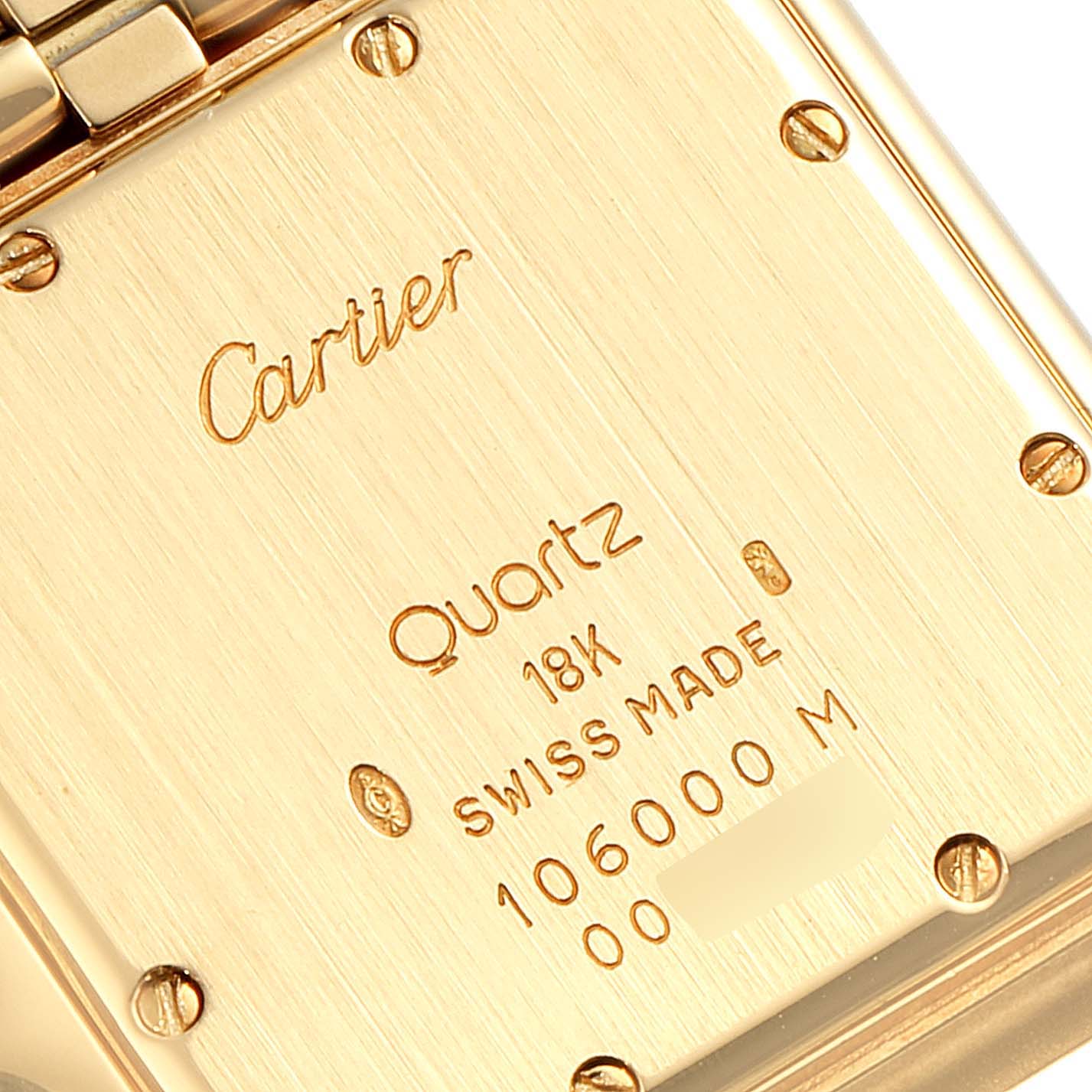 This image shows the back case of a Cartier Panthere W25014B9 Women's Yellow Gold Silver Dial W25014B9 Women's Yellow Gold Silver Dial watch, displaying its inscriptions and metal screws in close-up.