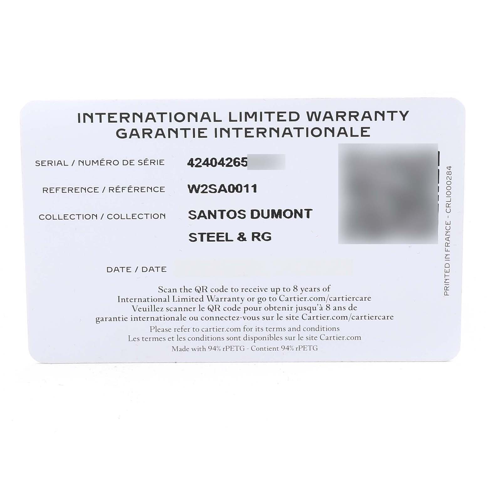The image shows an International Limited Warranty card for the Cartier Santos Dumont W2SA0011 Men's Stainless Steel Silver Dial model from a top-down angle.