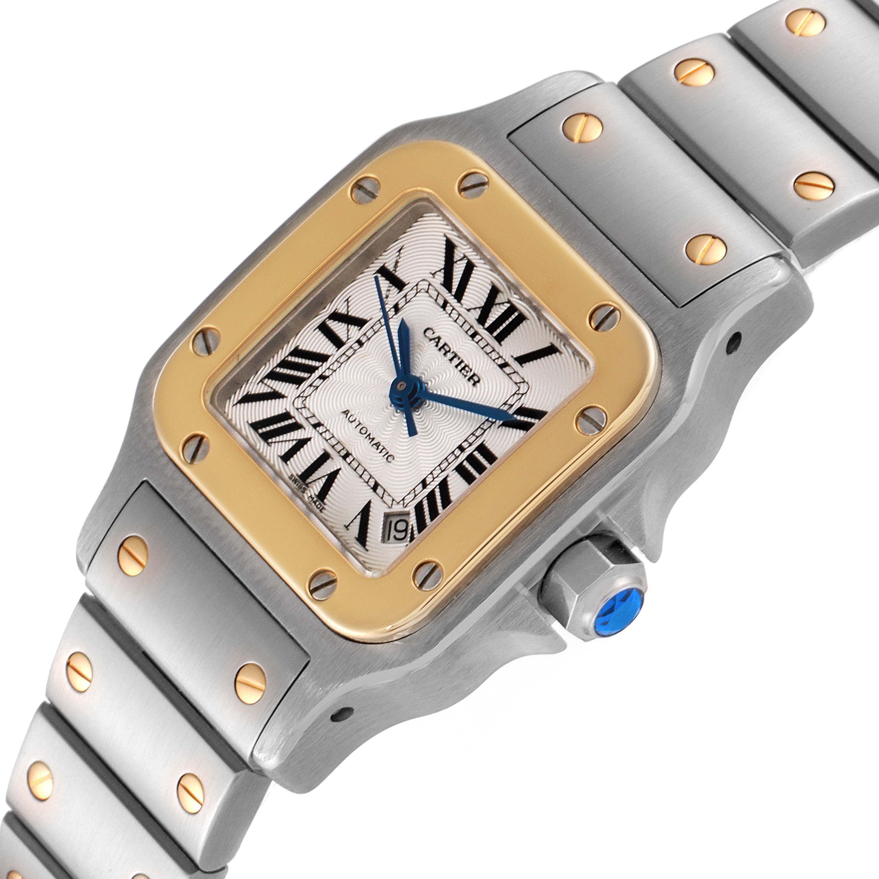 The Cartier Santos W20057C4 Women's Steel and Gold (two tone) Silver Dial W20057C4 Women's Steel and Gold (two tone) Silver Dial watch is shown at an angle displaying its dial, bezel, bracelet, and crown.