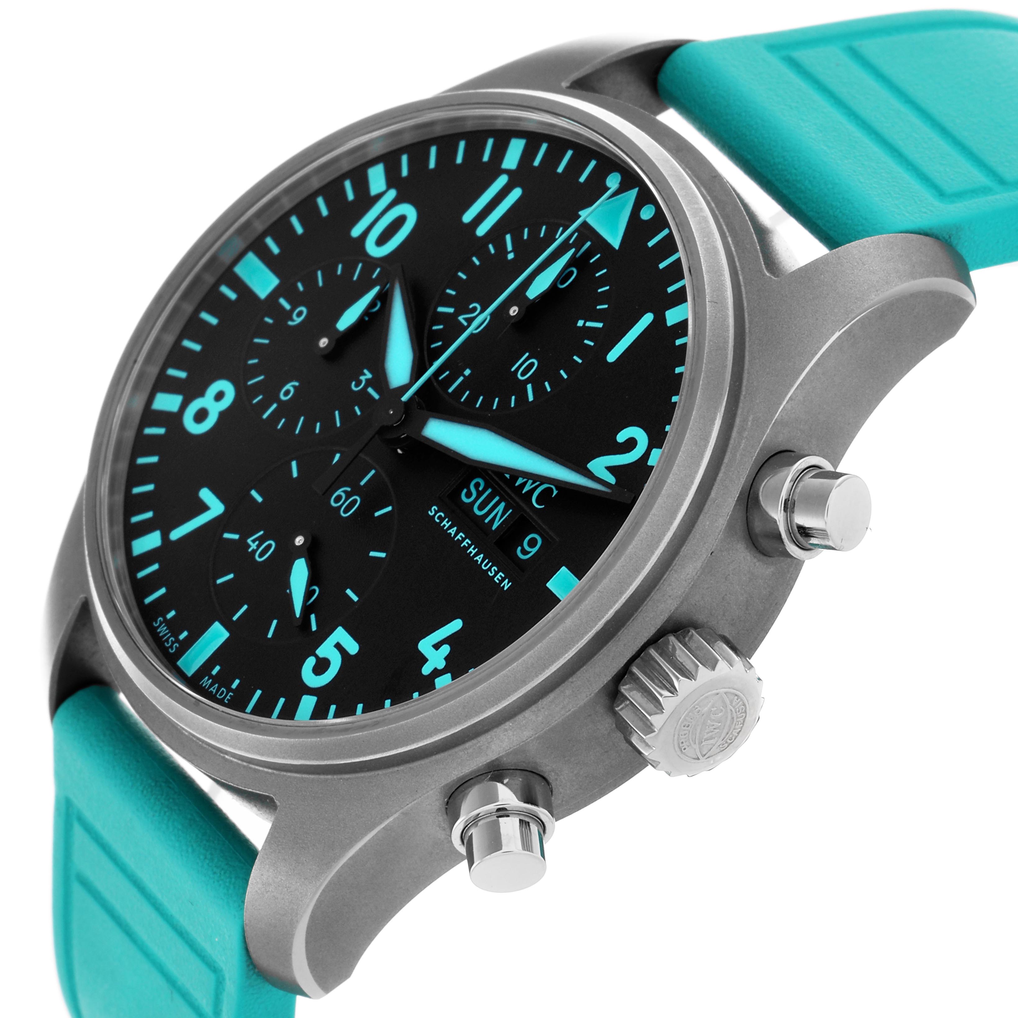 The IWC Pilot IW388108 Men's Titanium Black Dial IW388108 Men's Titanium Black Dial watch is shown at an angled side view, highlighting its face, crown, pushers, and turquoise strap.