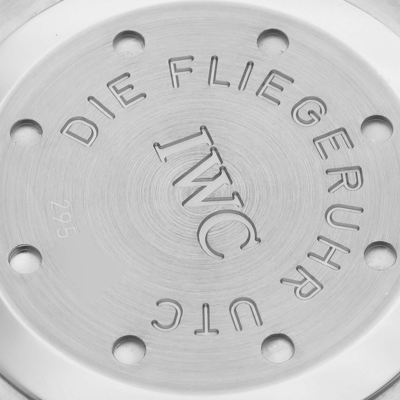 The image shows the case back of an IWC Pilot IW325105 Men's Stainless Steel Black Dial IW325105 Men's Stainless Steel Black Dial model watch, featuring the brand's engraving and a brushed metal finish.