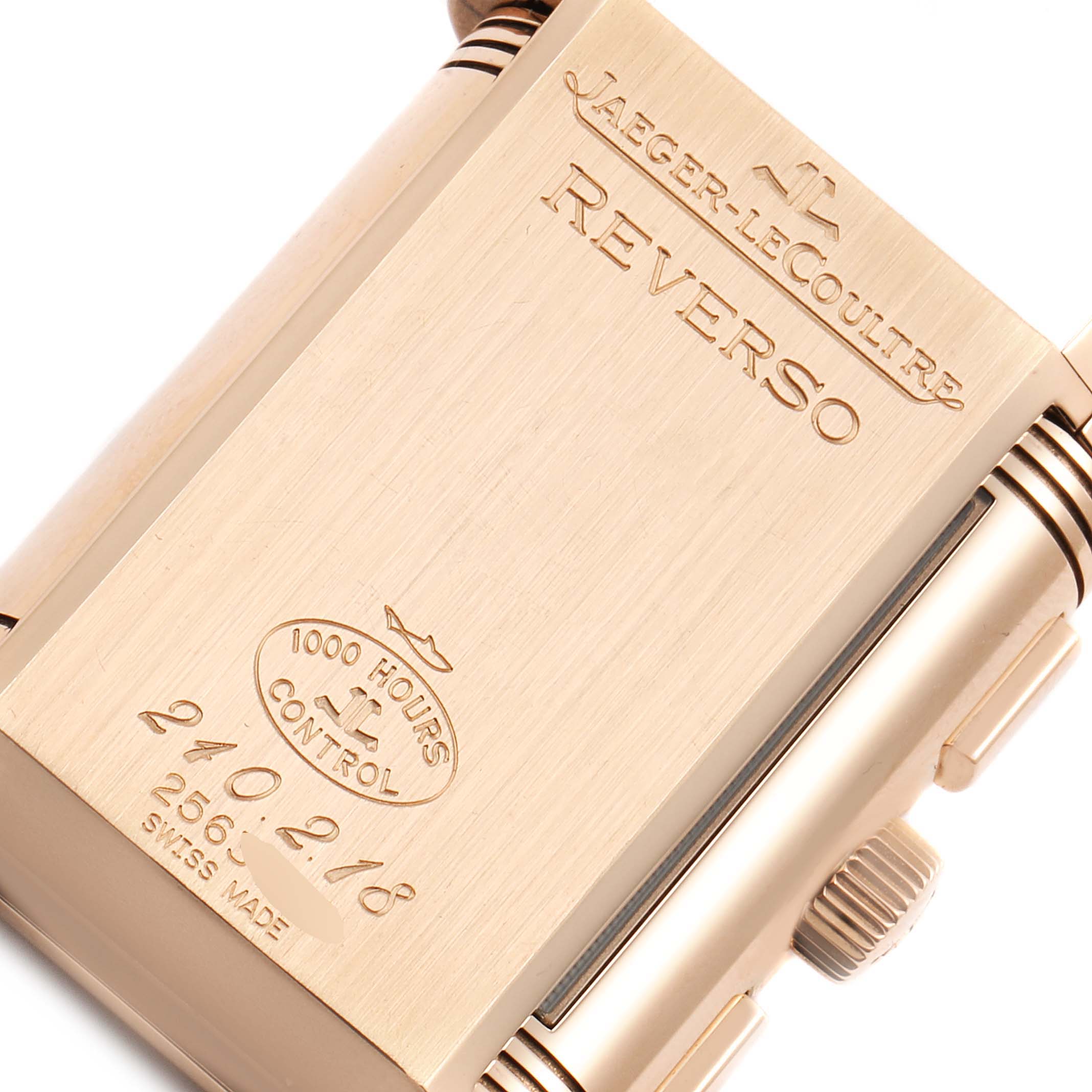 The image shows the back of the Jaeger-LeCoultre Reverso watch, highlighting brand engravings and control stamp.