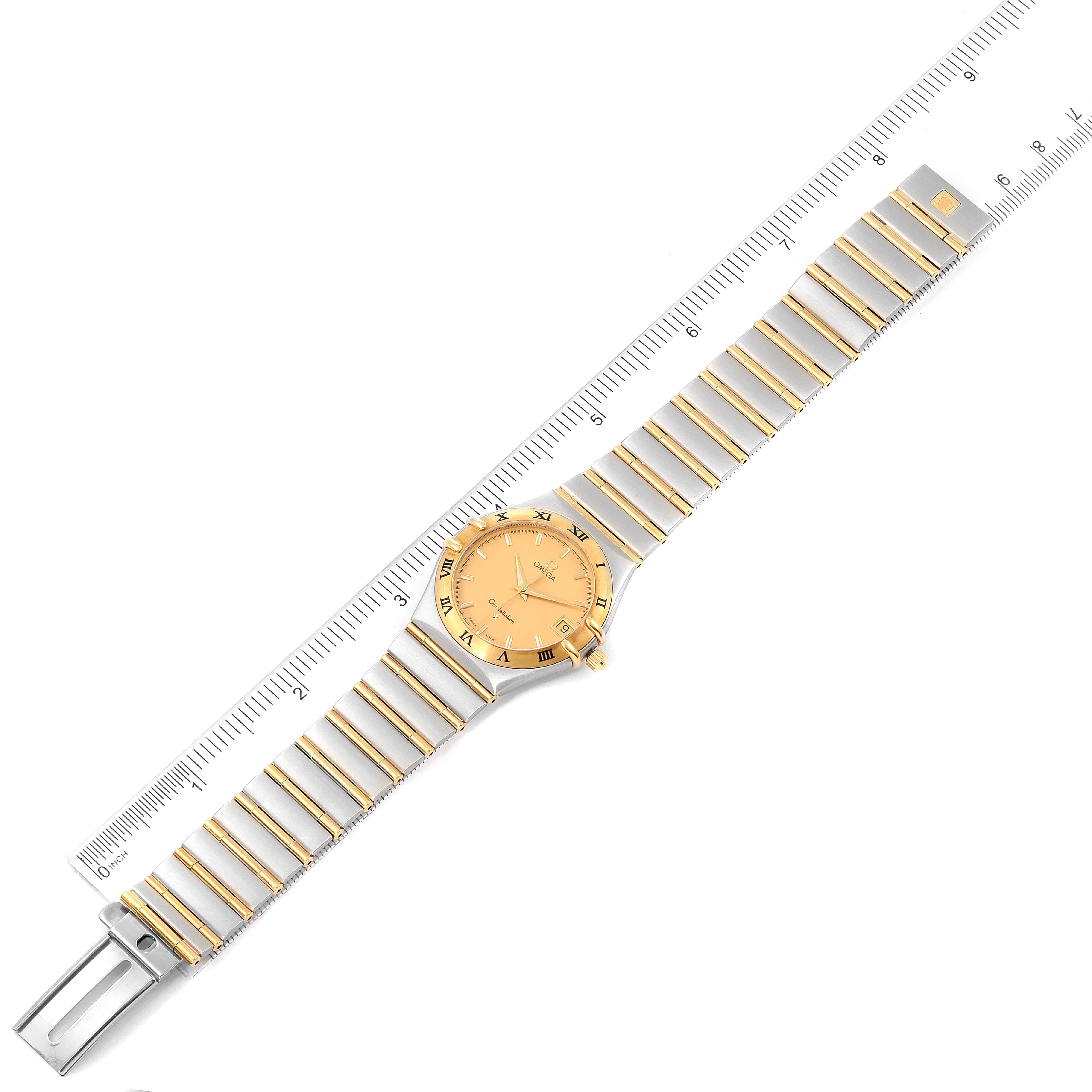 The image shows the Omega Constellation 1212.10.00 Men's Steel and Gold (two tone) Champagne Dial 1212.10.00 Men's Steel and Gold (two tone) Champagne Dial watch laid flat, with a ruler next to it for scale.