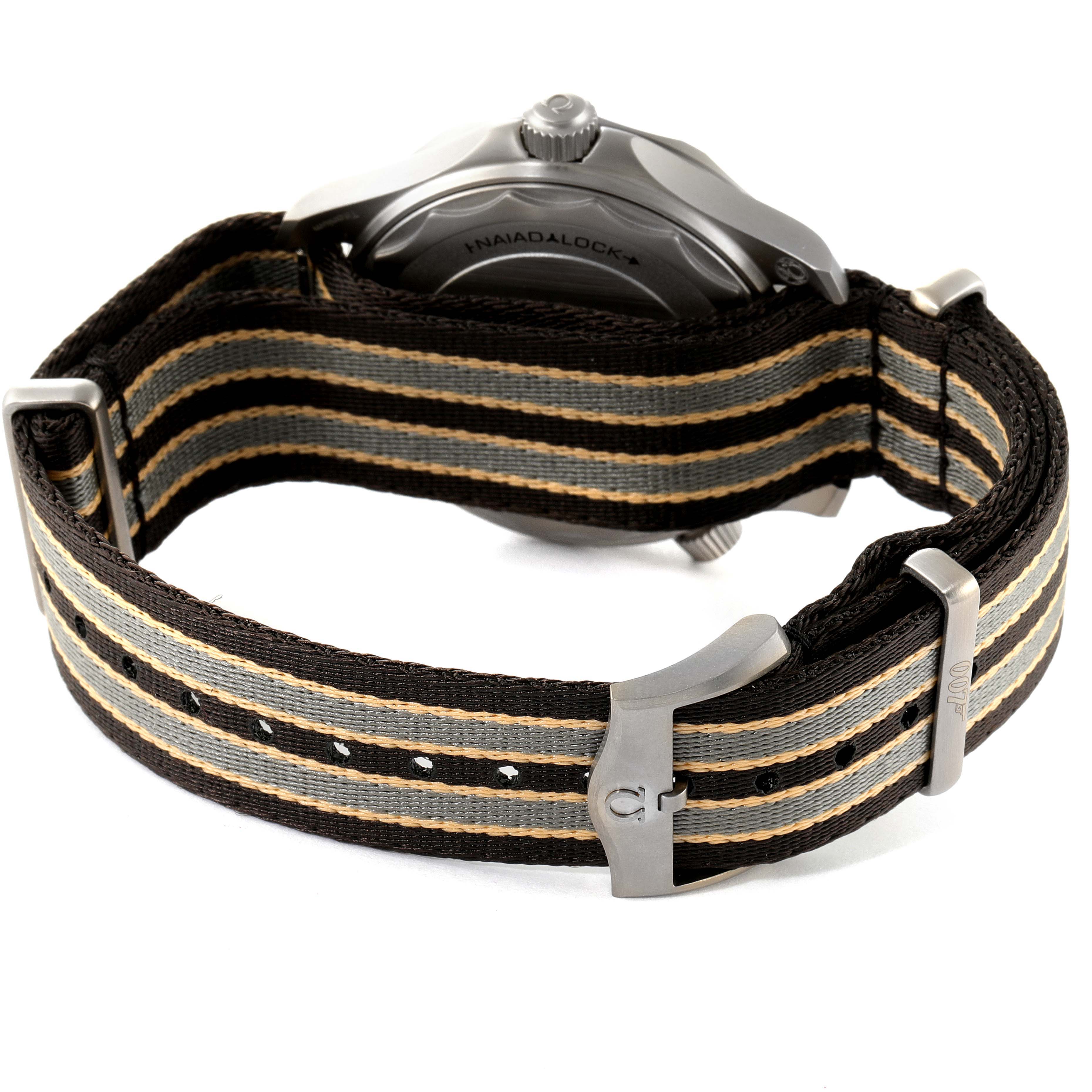 The image shows the back view of an Omega Seamaster 210.92.42.20.01.001 Men's Titanium Brown Dial 210.92.42.20.01.001 Men's Titanium Brown Dial with a striped NATO strap and the Naiad Lock system visible.