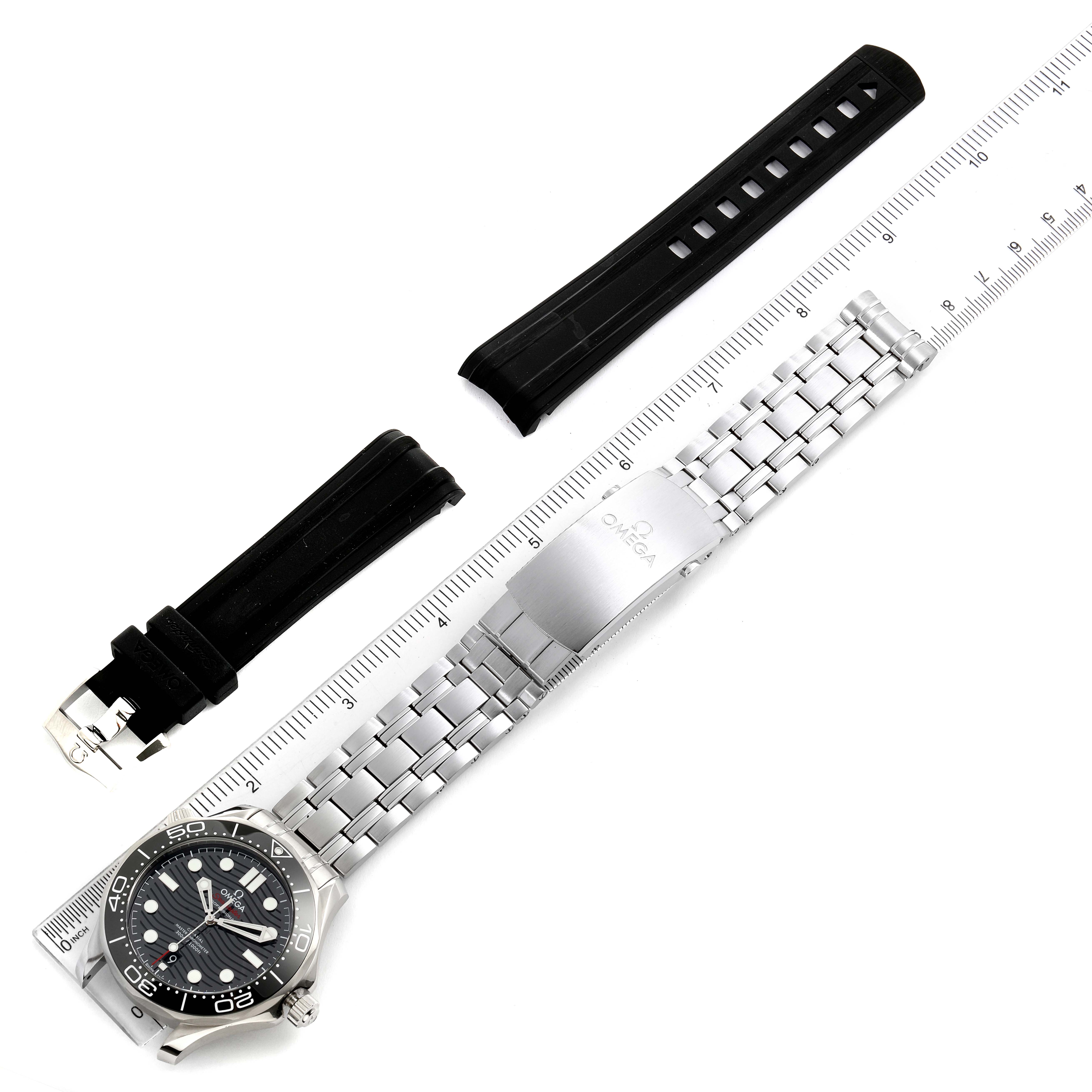 The image shows an Omega Seamaster 210.30.42.20.01.001 Men's Stainless Steel Black Dial 210.30.42.20.01.001 Men's Stainless Steel Black Dial watch with a stainless steel bracelet, a black rubber strap, and a ruler for scale.