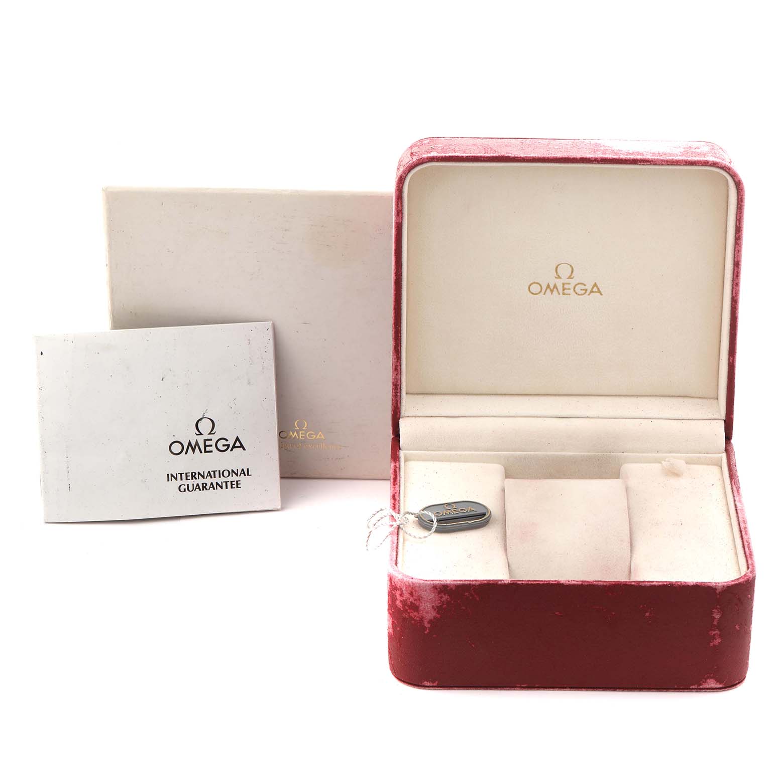 The image shows an angled view of an Omega Speedmaster 3510.20.00 Men's Stainless Steel White Dial 3510.20.00 Men's Stainless Steel White Dial watch box, guarantee card, and a tag inside the box.