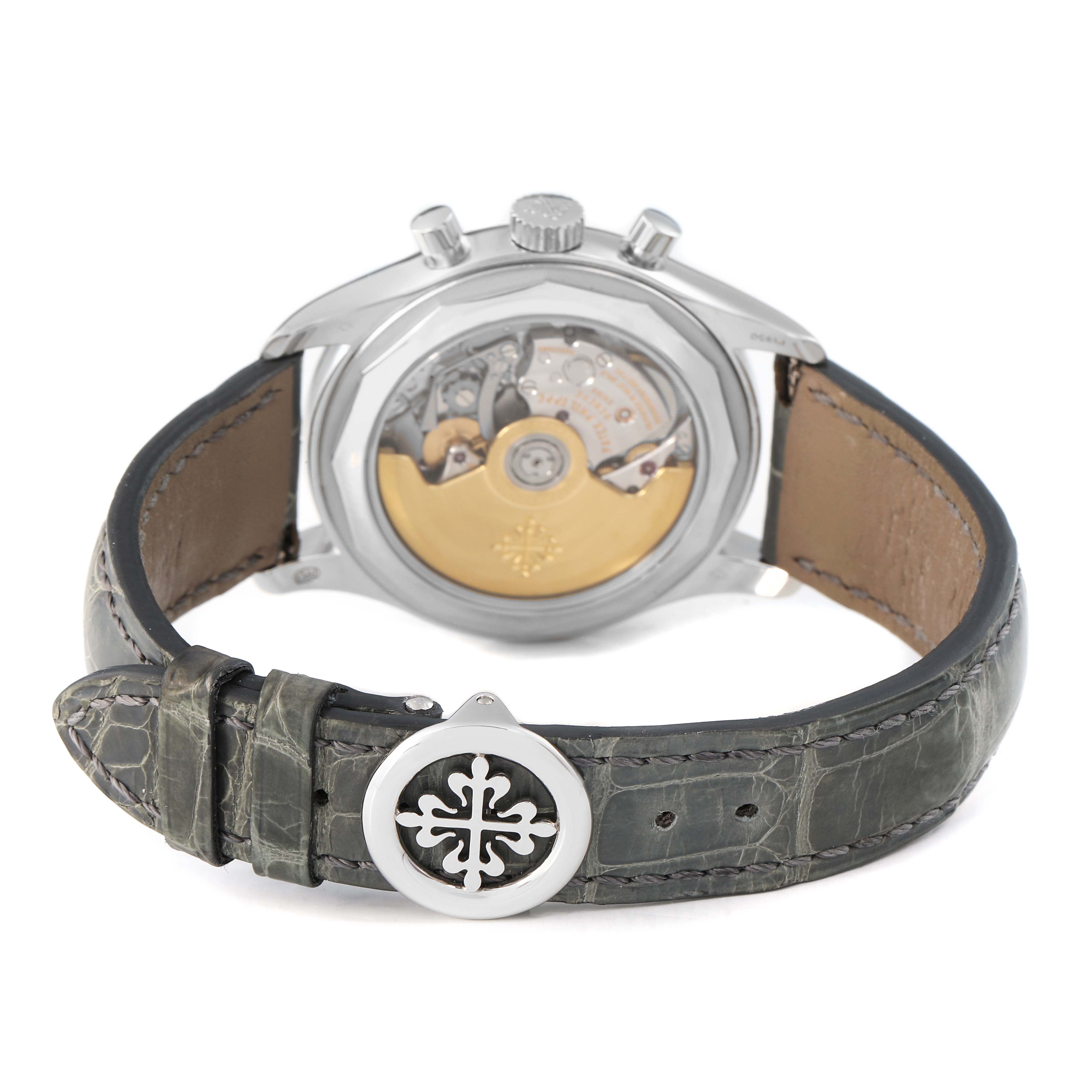 The Patek Philippe Complications 5960P-001 Men's Platinum Silver Dial watch is shown from the back, displaying the movement and leather strap with a decorative clasp.
