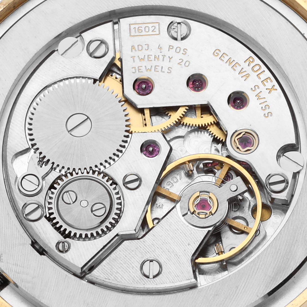 The image shows the movement of a Rolex Cellini 5115 Men's Yellow Gold Mother of Pearl Dial 5115 Men's Yellow Gold Mother of Pearl Dial watch from a top view, highlighting gears, jewels, and engraving details.