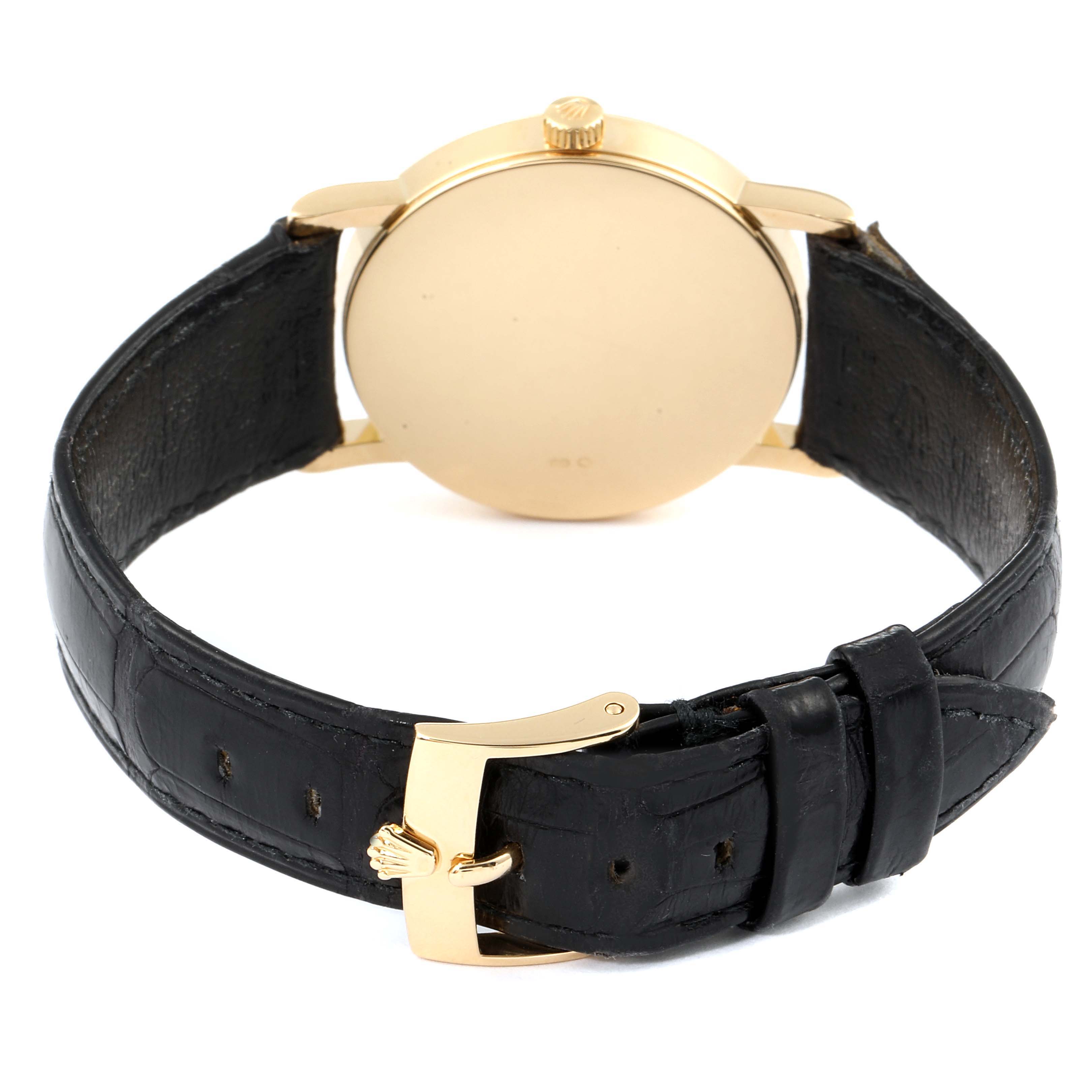 The image shows the back of a Rolex Cellini 5115 Men's Yellow Gold Silver Dial 5115 Men's Yellow Gold Silver Dial watch, including its gold case back, black leather strap, and gold buckle.