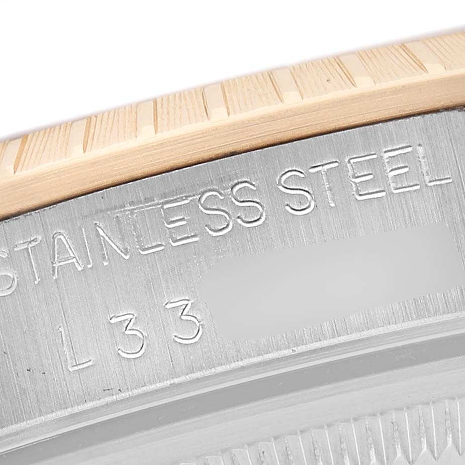 The image shows a close-up of the side and bezel of a Rolex Date 15223 Men's Steel and Gold (two tone) Champagne Dial model, featuring stainless steel and a gold edge.