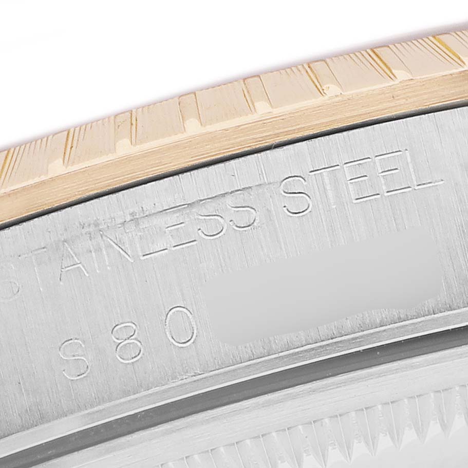 The image shows a close-up side view of the bezel and case back edge of a Rolex Date 15223 Men's Steel and Gold (two tone) Champagne Dial, highlighting engraved text.