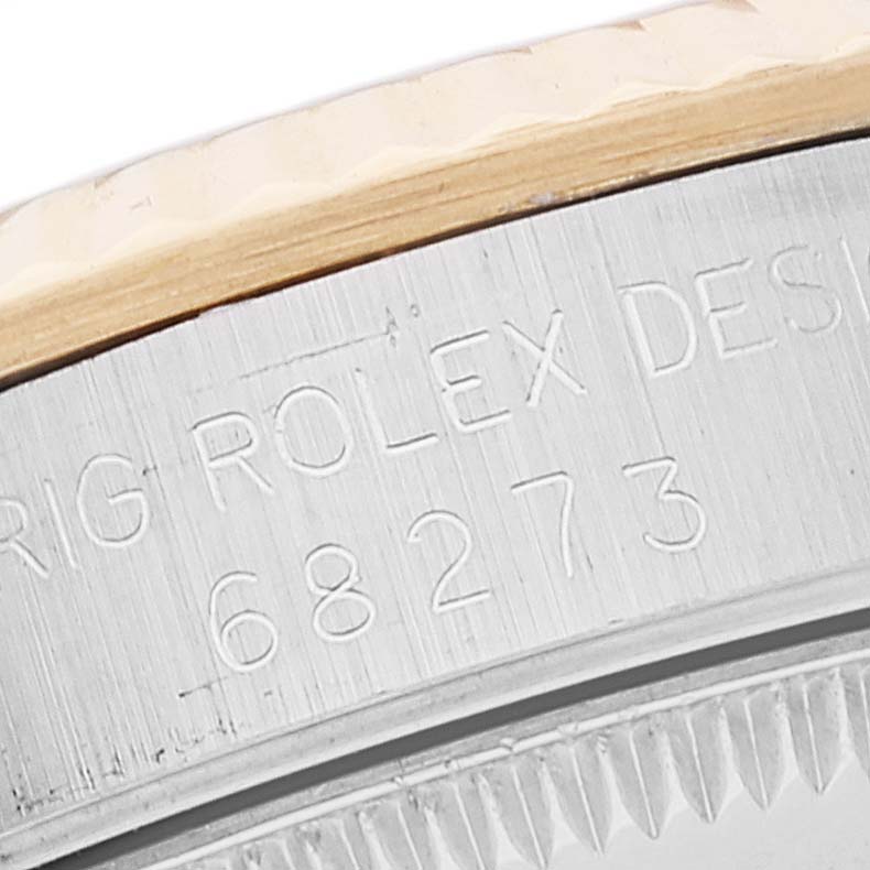 Close-up shot of a Rolex Mid-Size 68273 Women's Steel and Gold (two tone) White Dial 68273 Women's Steel and Gold (two tone) White Dial model showing the engraved serial number and part of the bezel.