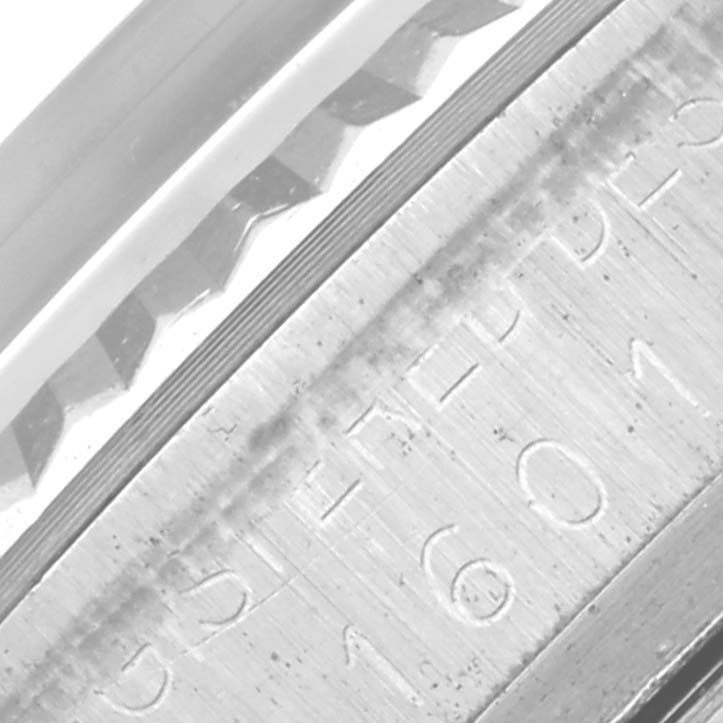 The image shows a close-up of the side of the Rolex Datejust 1601 Men's Stainless Steel Grey Dial 1601 Men's Stainless Steel Grey Dial model, highlighting the fluted bezel and part of the etched serial number.