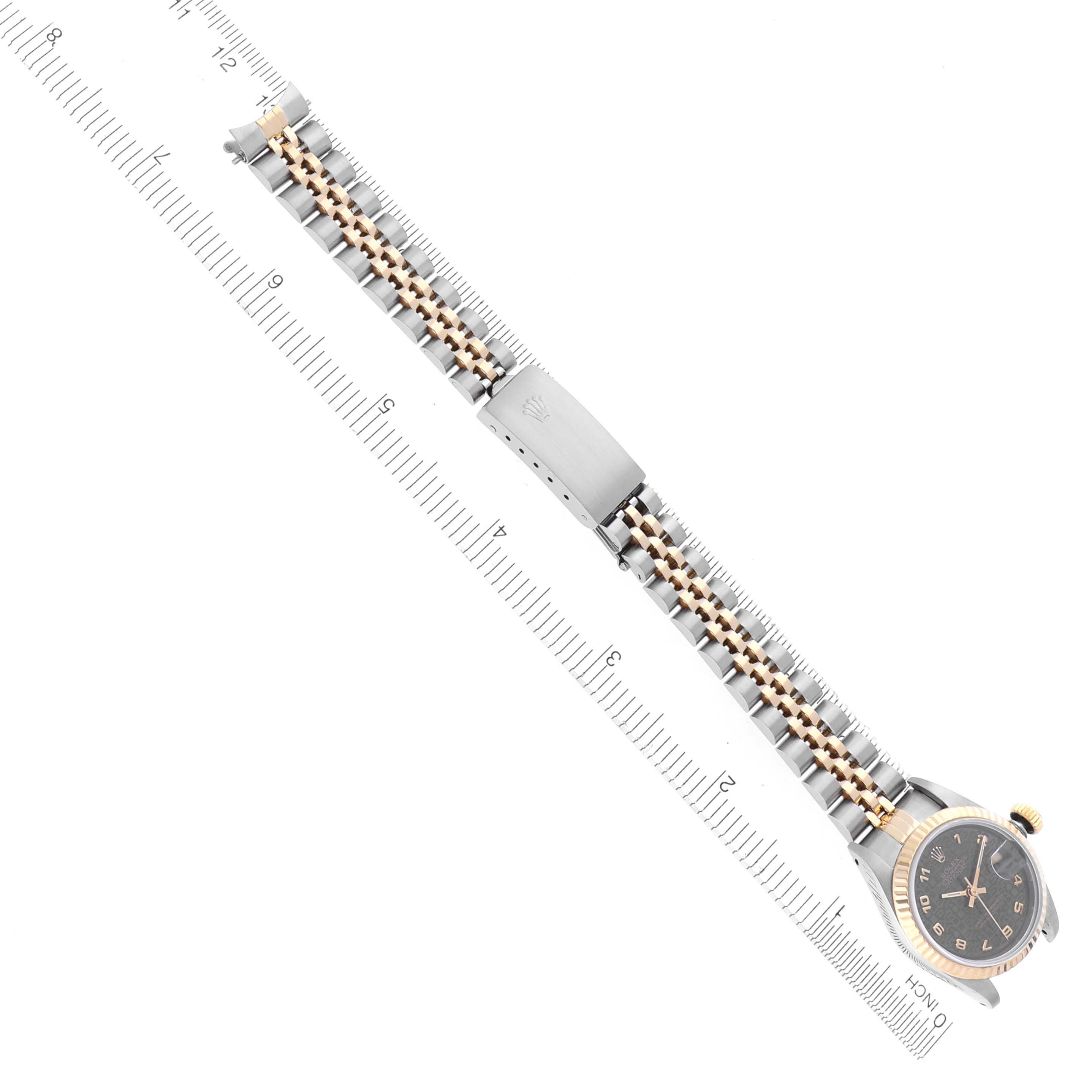 The image shows a top view of a Rolex Datejust 69173 Women's Steel and Gold (two tone) Black Dial 69173 Women's Steel and Gold (two tone) Black Dial watch with a two-tone bracelet and a ruler for size reference.