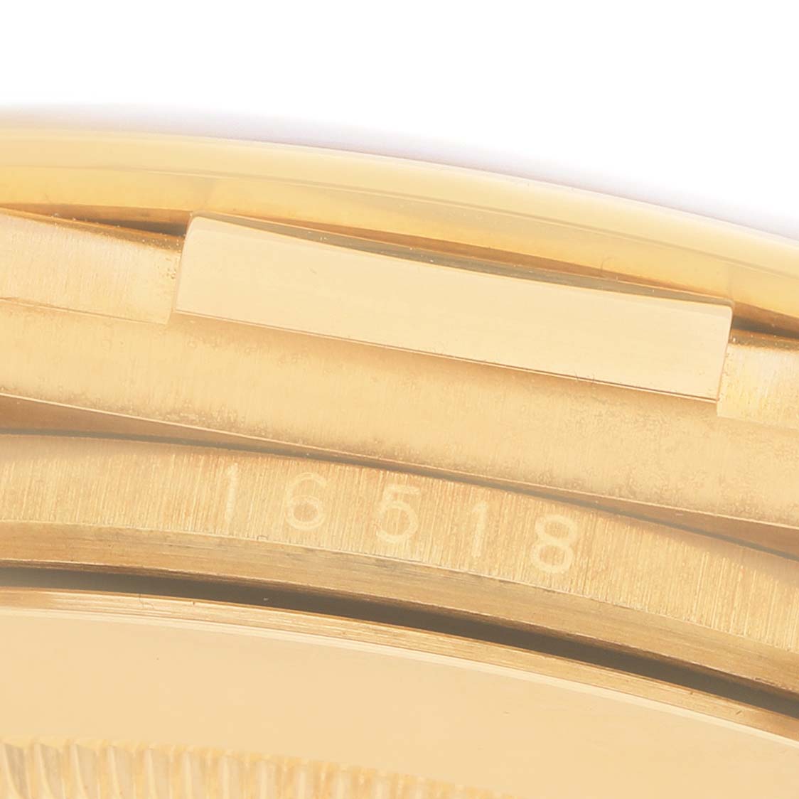 The image shows a close-up of the side profile of a Rolex Daytona 16518 Men's Yellow Gold White Dial, focusing on the case and serial number.