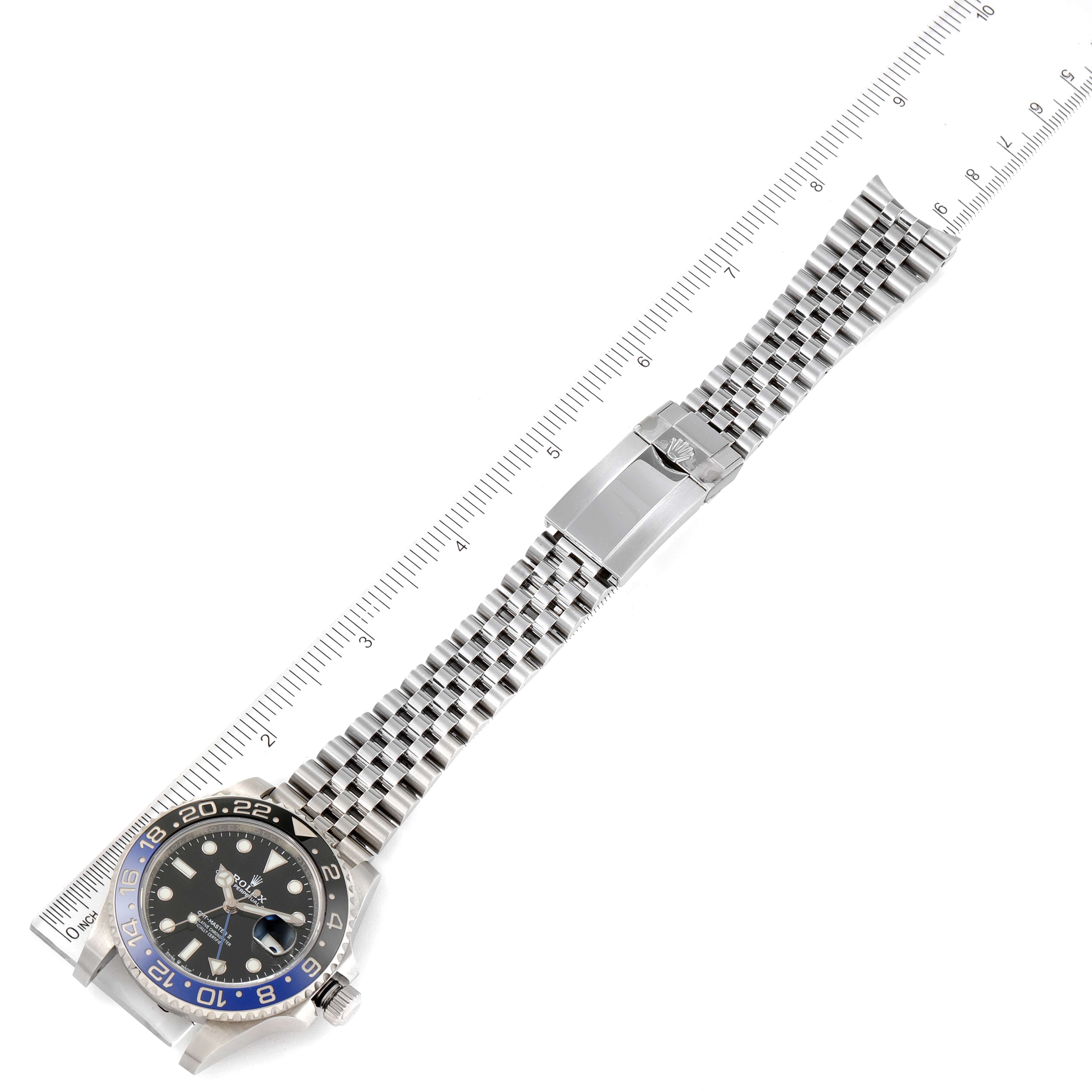 The image shows a top-down view of a Rolex GMT-Master 126710 Men
s Stainless Steel Black Dial 126710 Men
s Stainless Steel Black Dial watch with a metal bracelet and a ruler for scale.