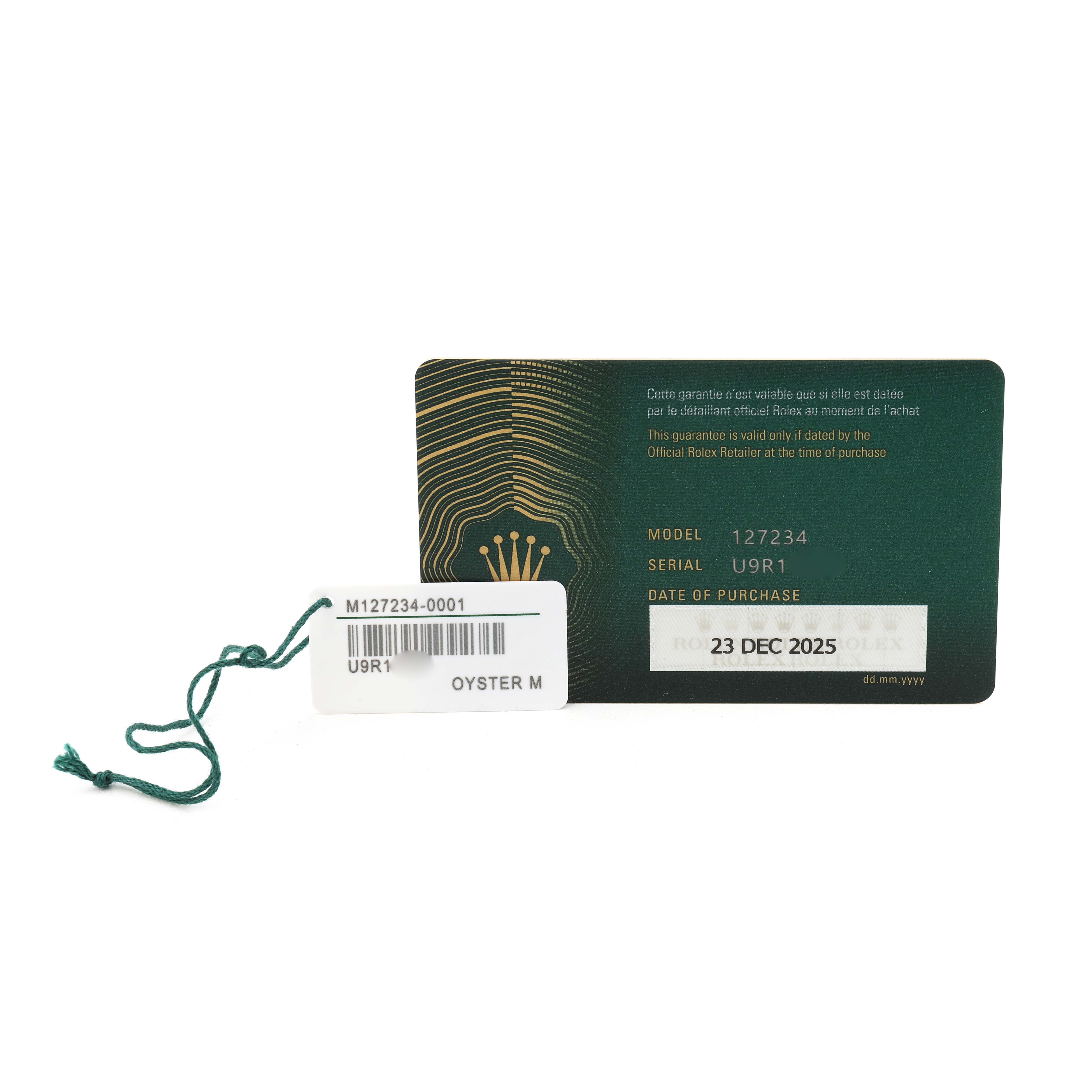 The image shows a warranty card and tag for a Rolex Land‑Dweller 127234 Men's Steel and Gold (two tone) Silver Dial.