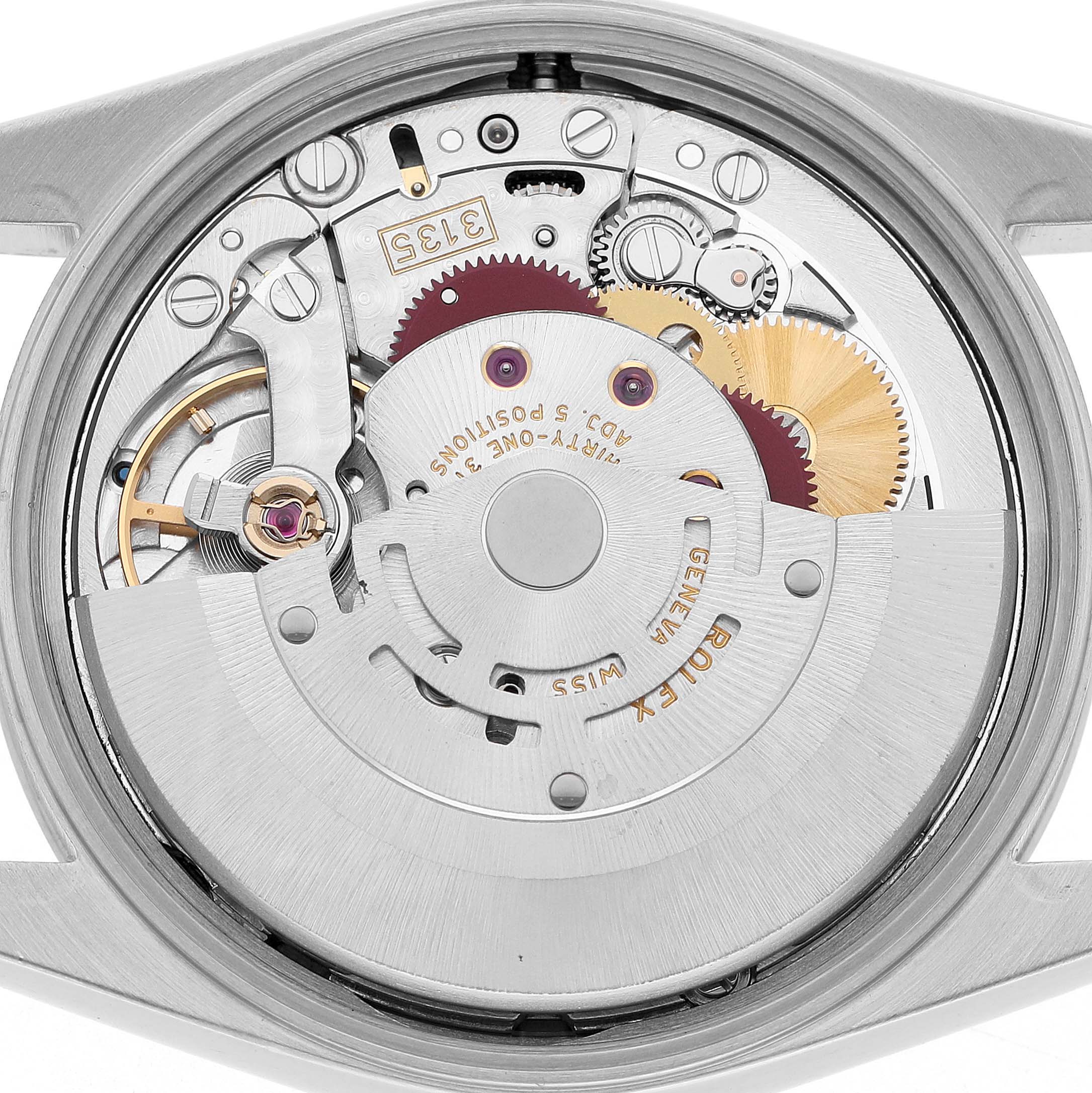 The image shows the movement of a Rolex Date 15200 Men's Stainless Steel Black Dial model watch from the back, highlighting gears and mechanical components.
