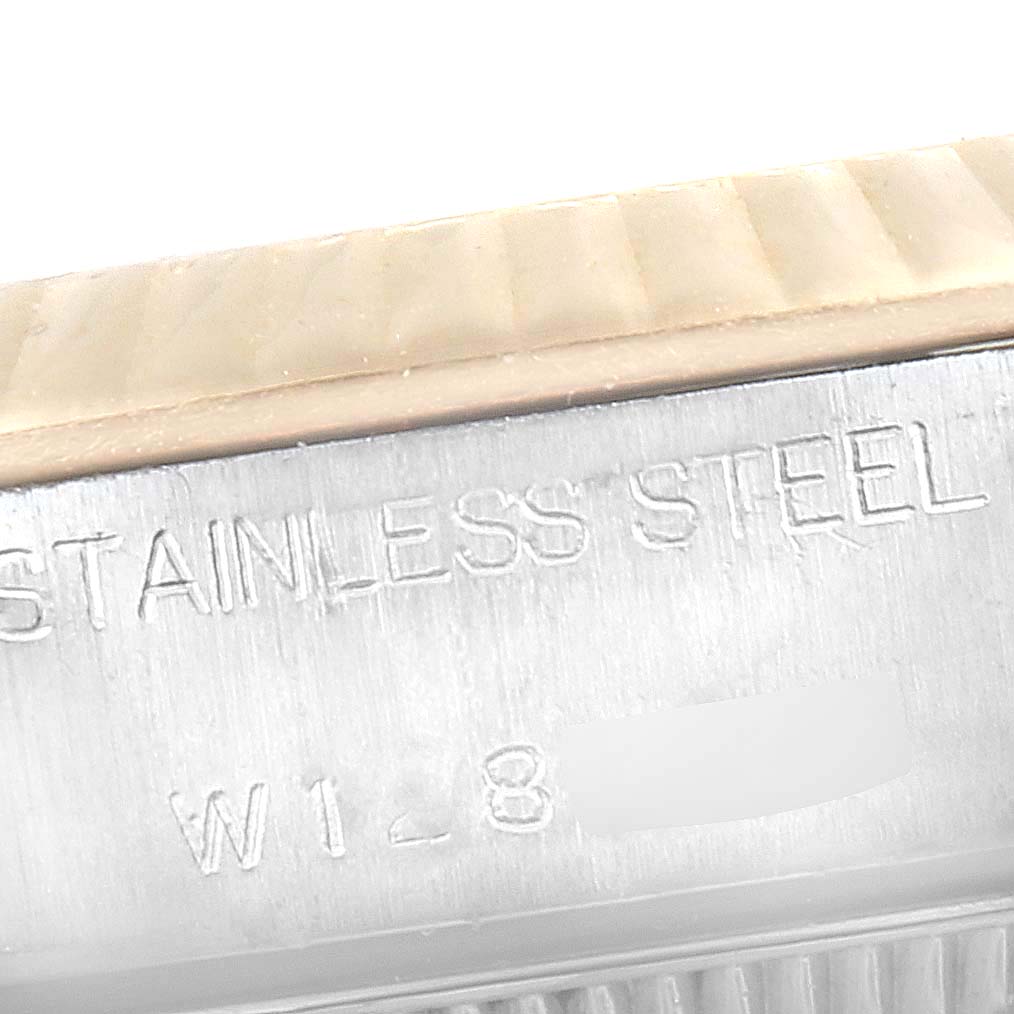 This close-up image of a Rolex Oyster Perpetual 67193 Women
s Steel and Gold (two tone) Black Dial 67193 Women
s Steel and Gold (two tone) Black Dial watch shows the side engraving with "STAINLESS STEEL" and partial serial number.