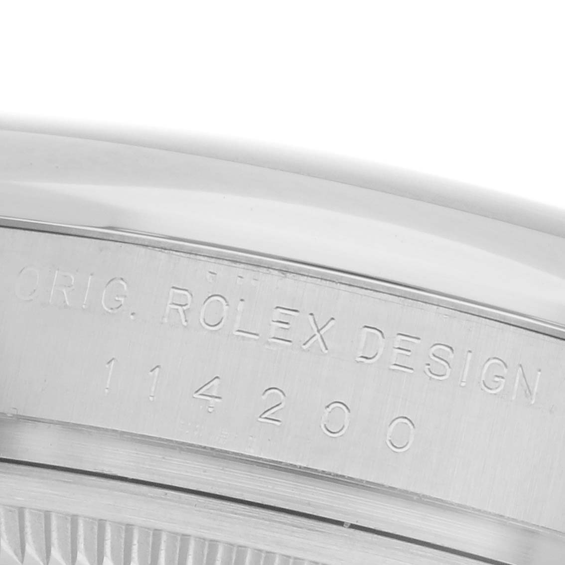 The close-up image shows the edge of the Rolex Oyster Perpetual 114200 Men's Stainless Steel Green Dial 114200 Men's Stainless Steel Green Dial watch case, featuring engraved text on the side.