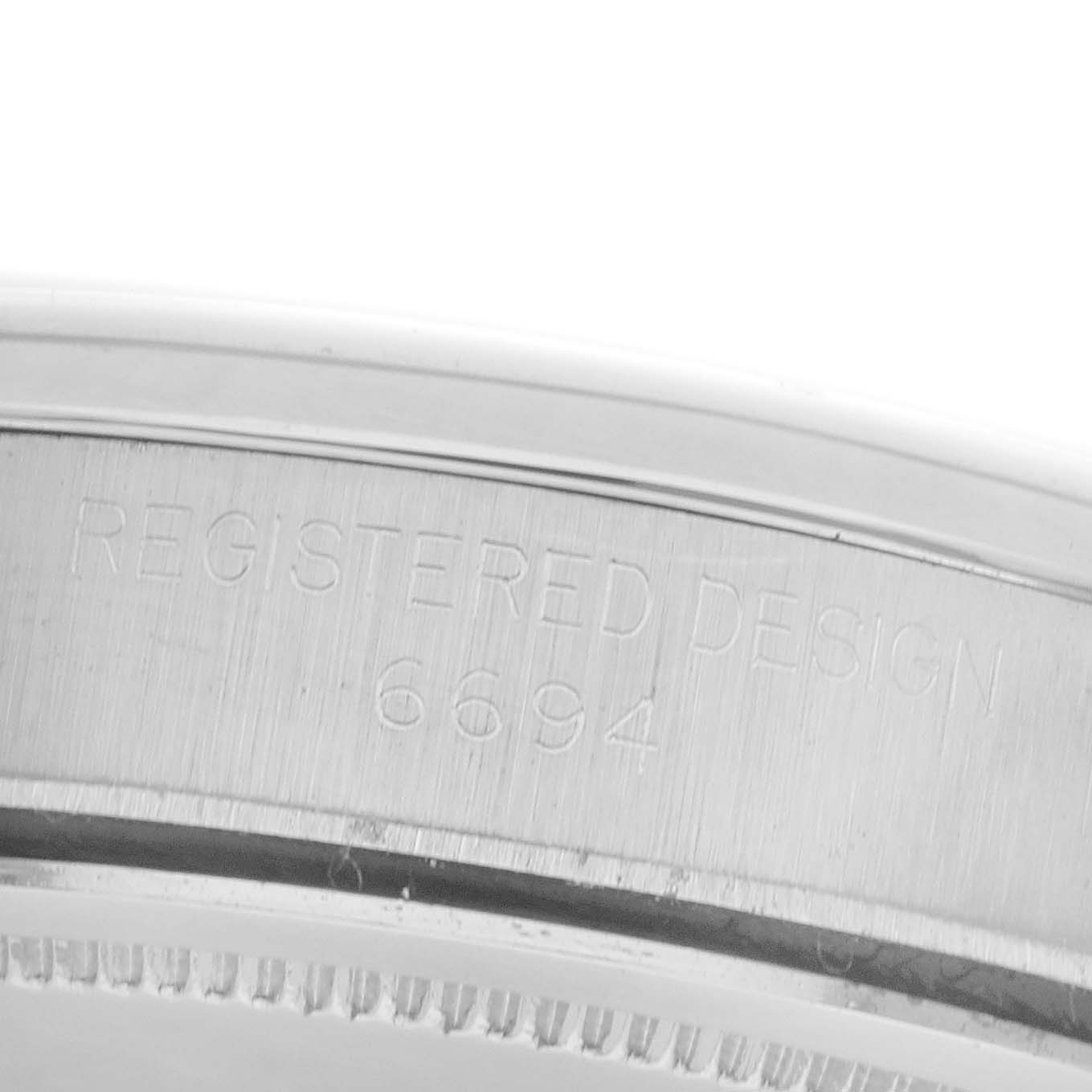 The image shows the side of a Rolex Date 6694 Men's Stainless Steel Silver Dial 6694 Men's Stainless Steel Silver Dial model case with "REGISTERED DESIGN 6694" engraved.