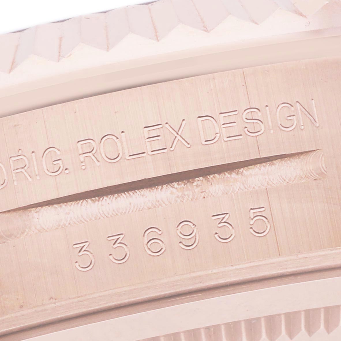 The image shows a close-up of the engraved bezel on a Rolex Sky-Dweller 336935 Men's Rose Gold Grey Dial watch, highlighting the "ROLEX DESIGN" text.