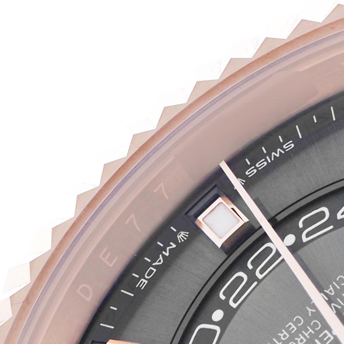 The image shows a close-up of the Rolex Sky-Dweller 336935 Men's Rose Gold Grey Dial's bezel and part of its dial, including hour markers and hands, from an angled top view.