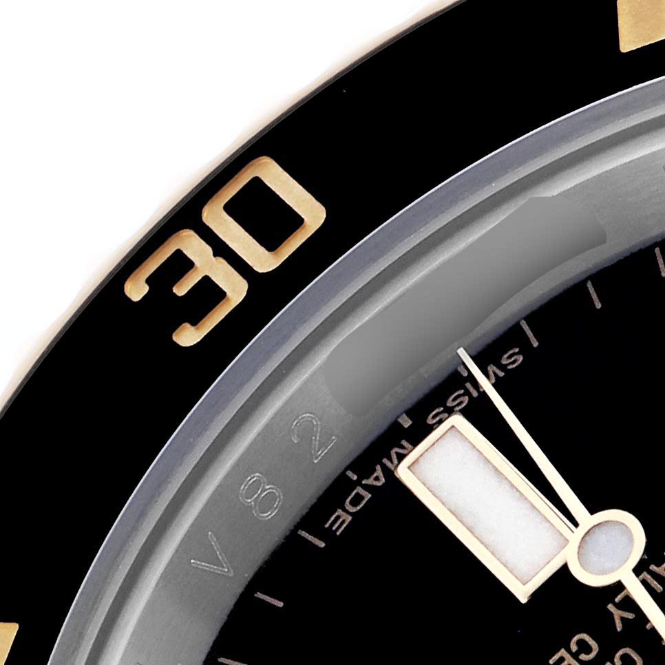 This close-up image of the Rolex Submariner 116613 Men's Steel and Gold (two tone) Black Dial 116613 Men's Steel and Gold (two tone) Black Dial shows part of the bezel, dial, and minute hand.