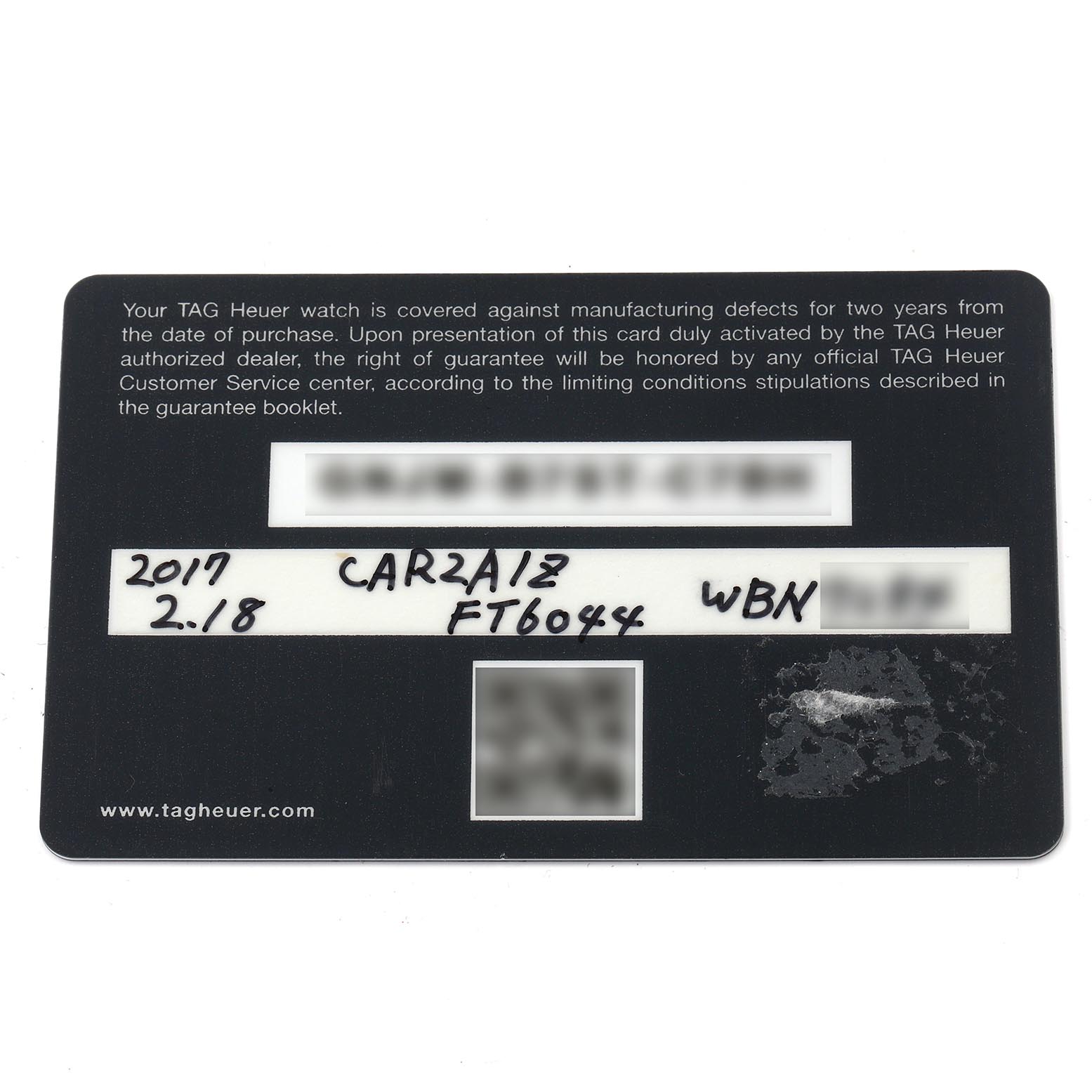 The image shows a warranty card for a Tag Heuer Carrera CAR2A1Z.FT6051 Men's Stainless Steel Black Dial CAR2A1Z.FT6051 Men's Stainless Steel Black Dial watch with model details, viewed from above.