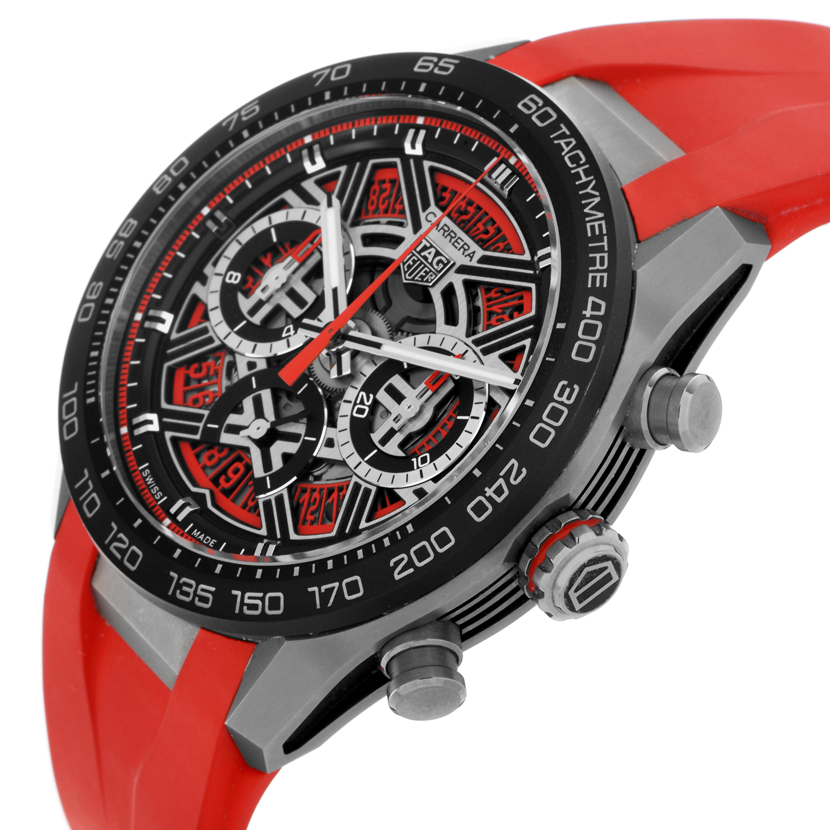 The Tag Heuer Carrera CBU2082 Men
s Titanium Red Dial CBU2082 Men
s Titanium Red Dial watch is shown at an angle displaying the dial, tachymeter bezel, pushers, and crown with a red strap.