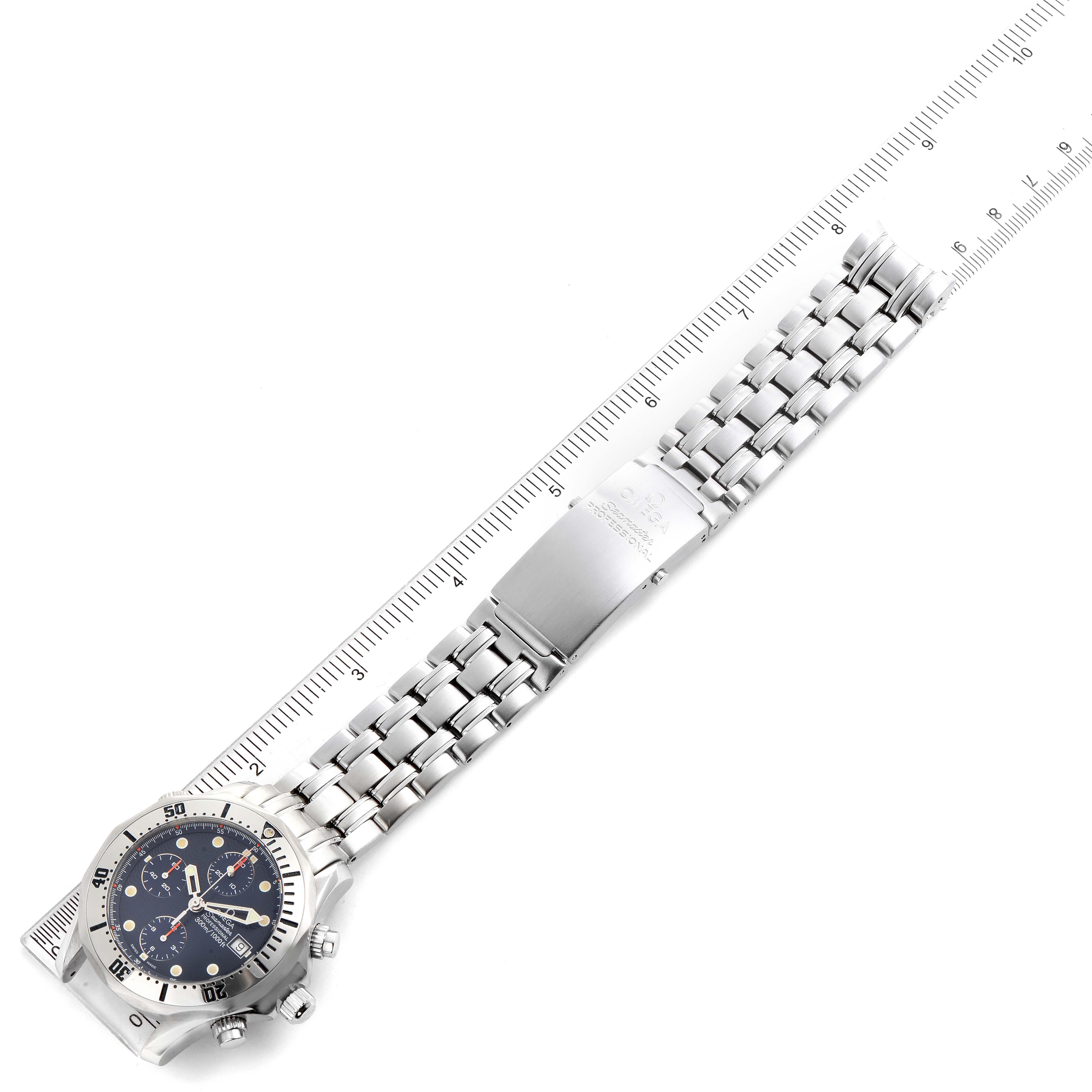 The Omega Seamaster 2598.80.00 Men
s Stainless Steel Blue Dial 2598.80.00 Men
s Stainless Steel Blue Dial watch is displayed from an overhead angle with a full view of its band and clasp, next to a ruler for scale.