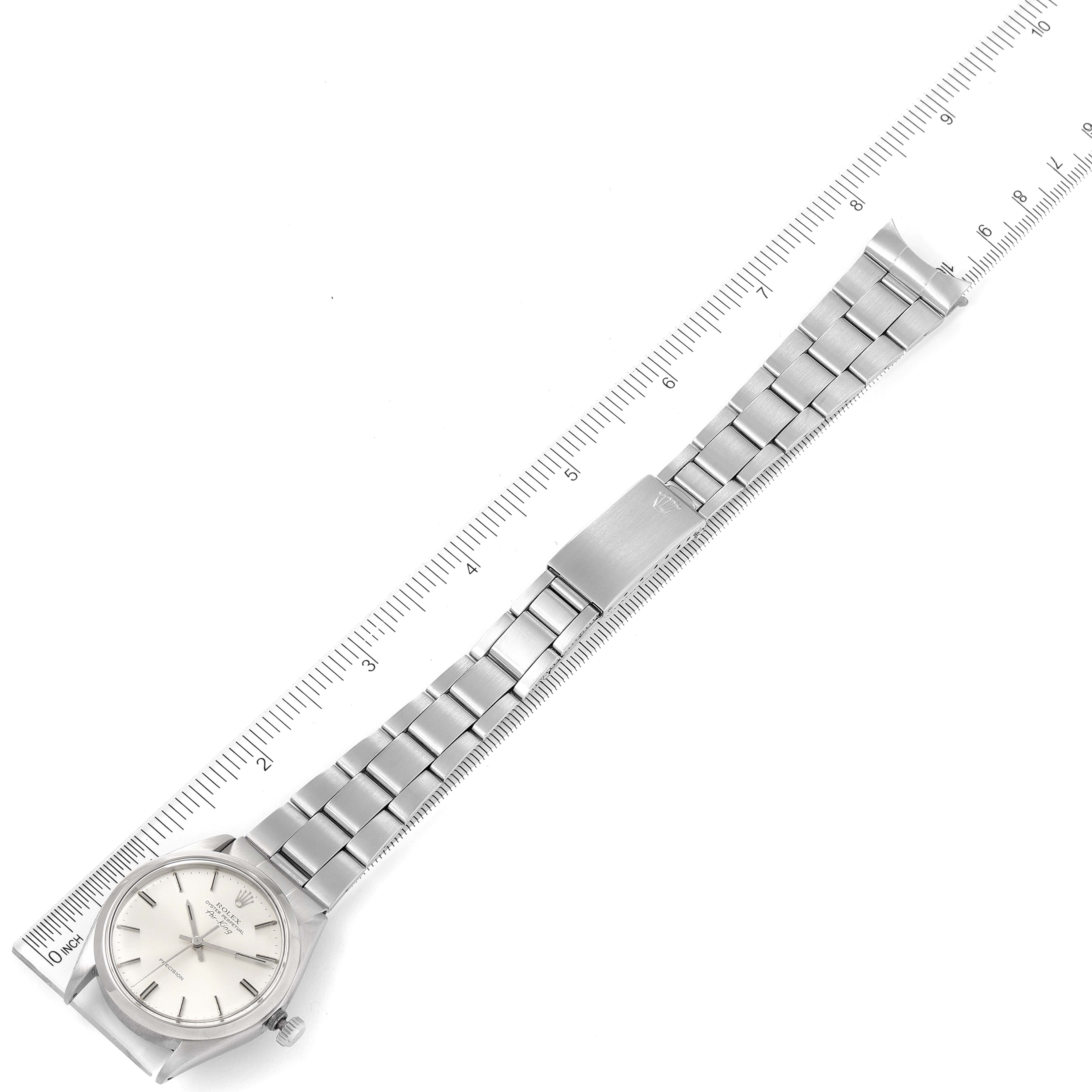 The image shows a top-down view of a Rolex Air-King 5500 Men's Stainless Steel Silver Dial 5500 Men's Stainless Steel Silver Dial watch, displaying the face, bezel, and full-length metal bracelet alongside a ruler.