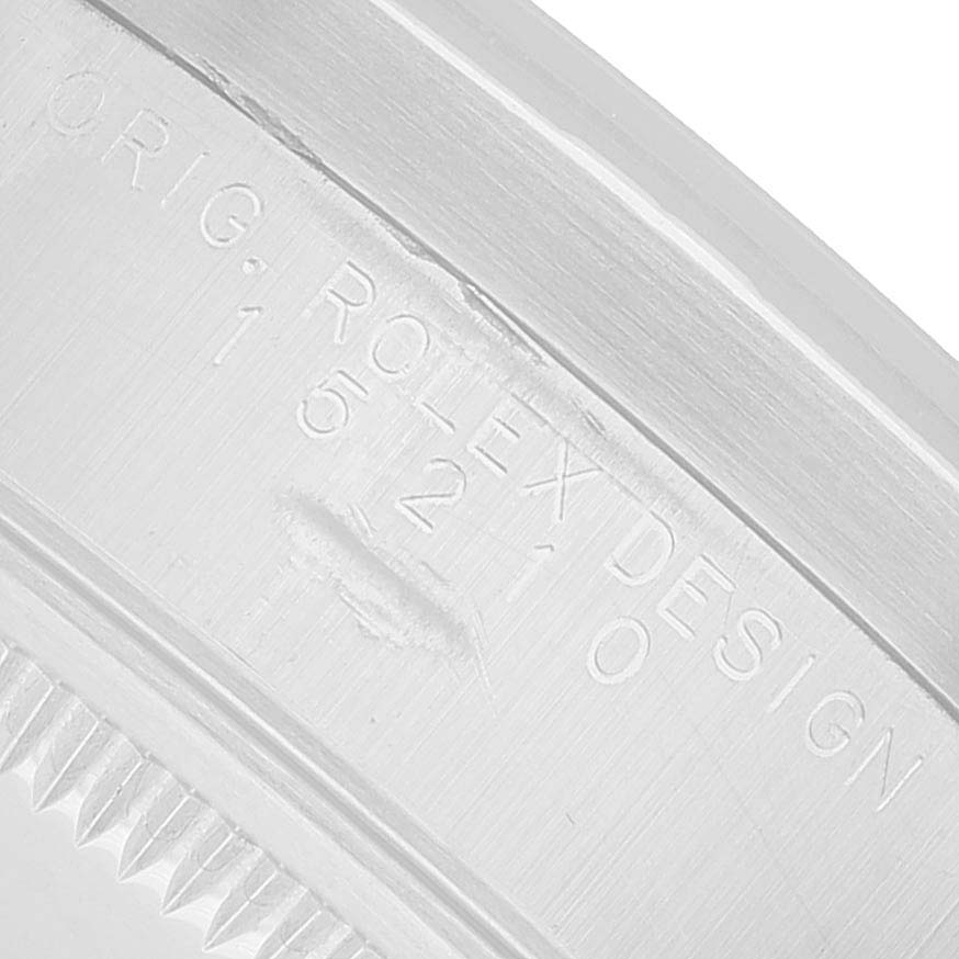 The image shows an engraved section of a Rolex Date 15210 Men's Stainless Steel Pink Dial watch case with visible text and part of the bezel.