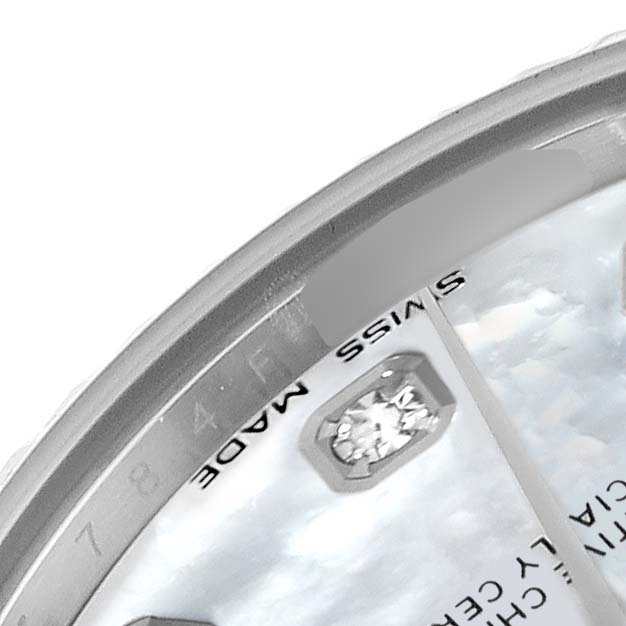 The image shows a close-up of the dial, bezel, and a diamond marker of a Mid-Size Rolex watch.