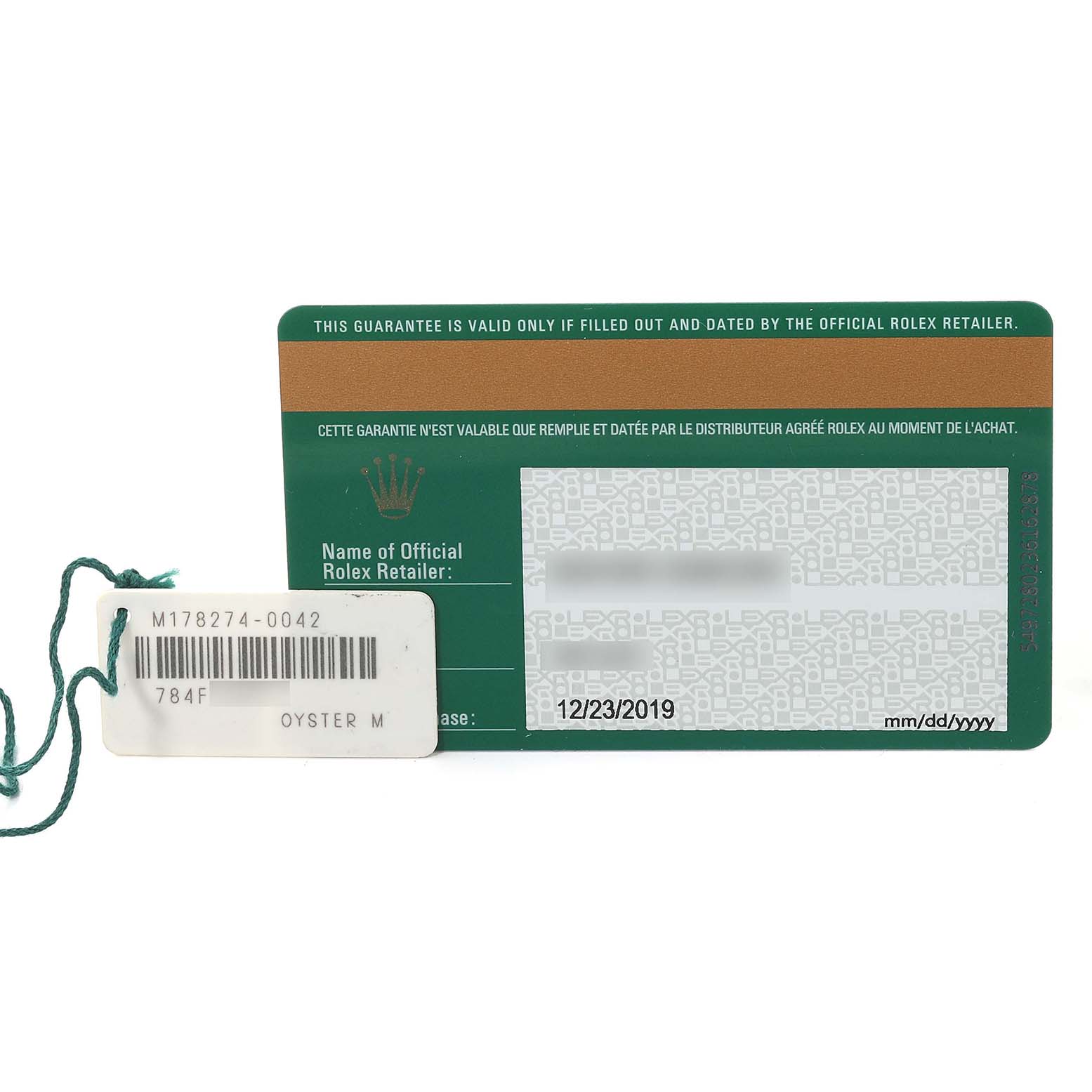 The image shows the warranty card and tag for a Mid-Size Rolex Oyster M watch, photographed from the front.