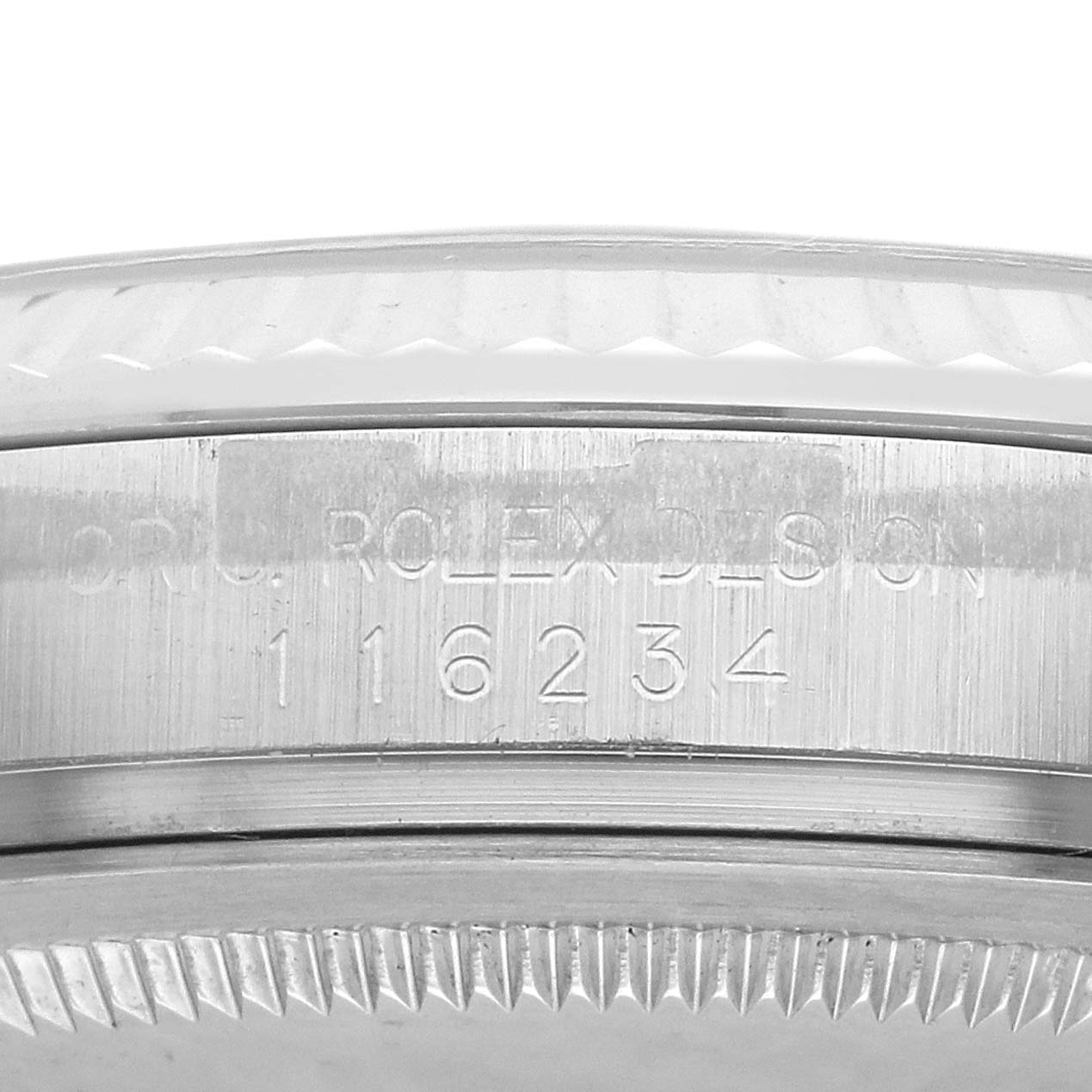 The image shows a close-up of the side of a Rolex Datejust 116234 Men's Stainless Steel Silver Dial 116234 Men's Stainless Steel Silver Dial, focusing on the engraved serial and model numbers on the case.