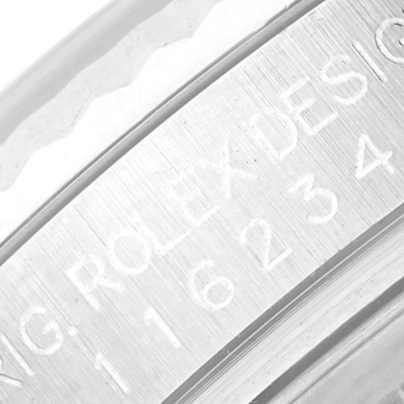 The image shows a close-up of the inner bezel engraving on a Rolex Datejust 116234 Men's Stainless Steel Silver Dial 116234 Men's Stainless Steel Silver Dial watch with the serial number partially visible.