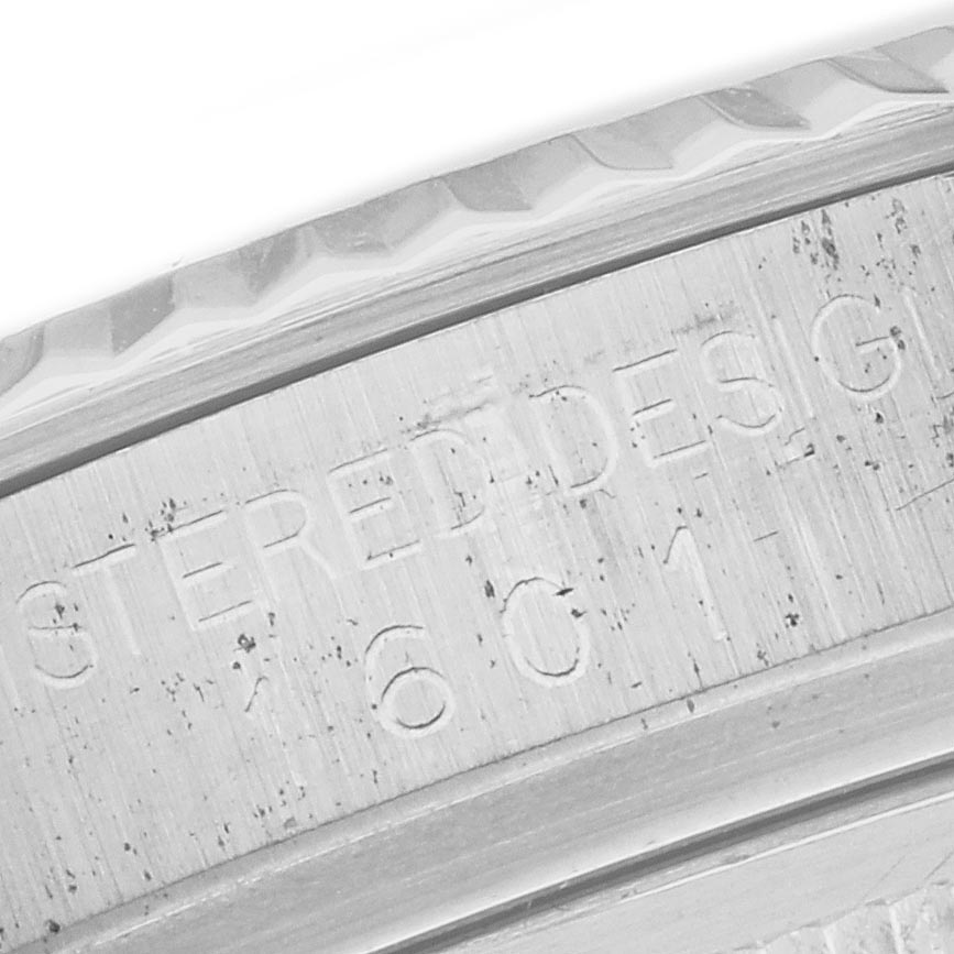 The image shows a close-up of the edge of the bezel and engraving on a Rolex Datejust 1601 Men's Stainless Steel White Dial 1601 Men's Stainless Steel White Dial's case.