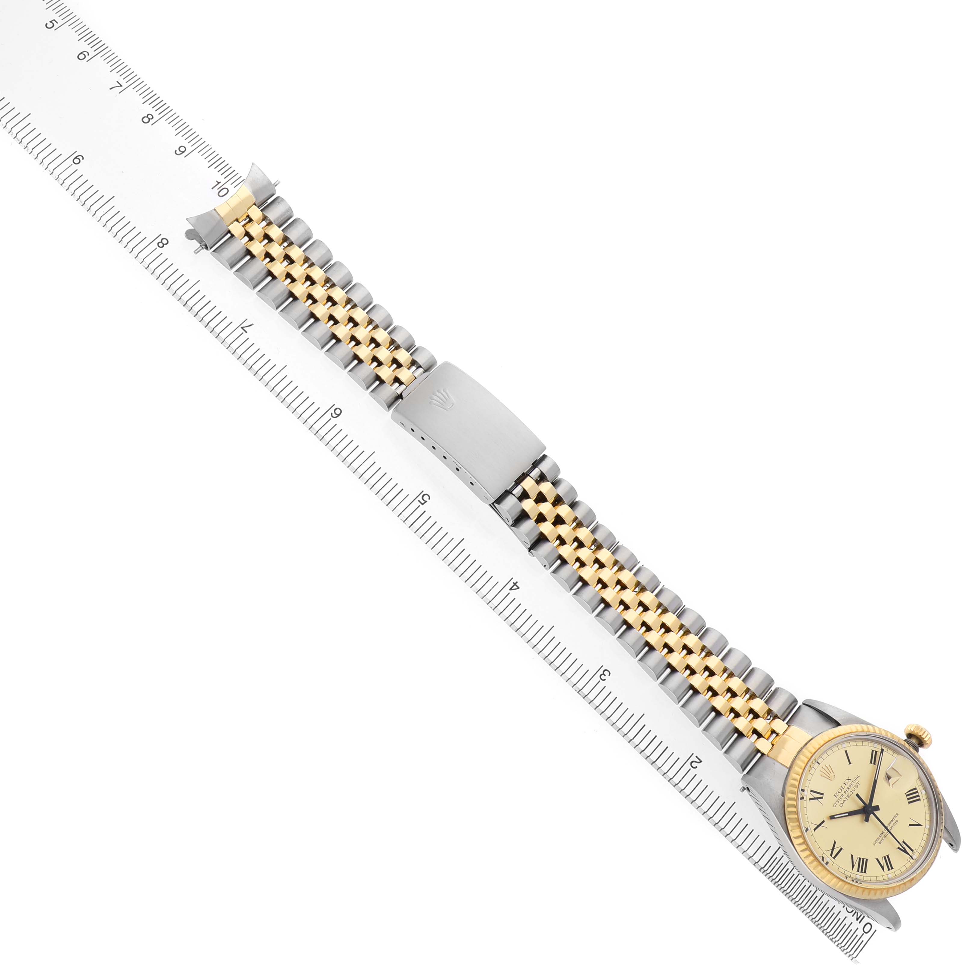 The Rolex Datejust 16013 Men's Steel and Gold (two tone) Champagne Dial watch is shown from the side, featuring the bracelet and clasp next to a ruler for measurement.
