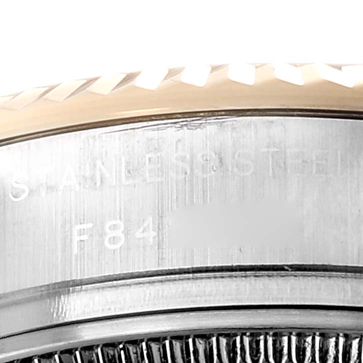 This image shows a close-up of the side of a Rolex Datejust 179173 Women's Steel and Gold (two tone) Mother of Pearl Dial 179173 Women's Steel and Gold (two tone) Mother of Pearl Dial watch, highlighting the bezel, part of the case, and engraved text.