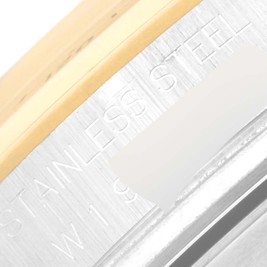 This close-up image of a Rolex Daytona 16523 Men's Steel and Gold (two tone) Champagne Dial 16523 Men's Steel and Gold (two tone) Champagne Dial watch shows part of the engraved stainless steel case and the gold bezel.