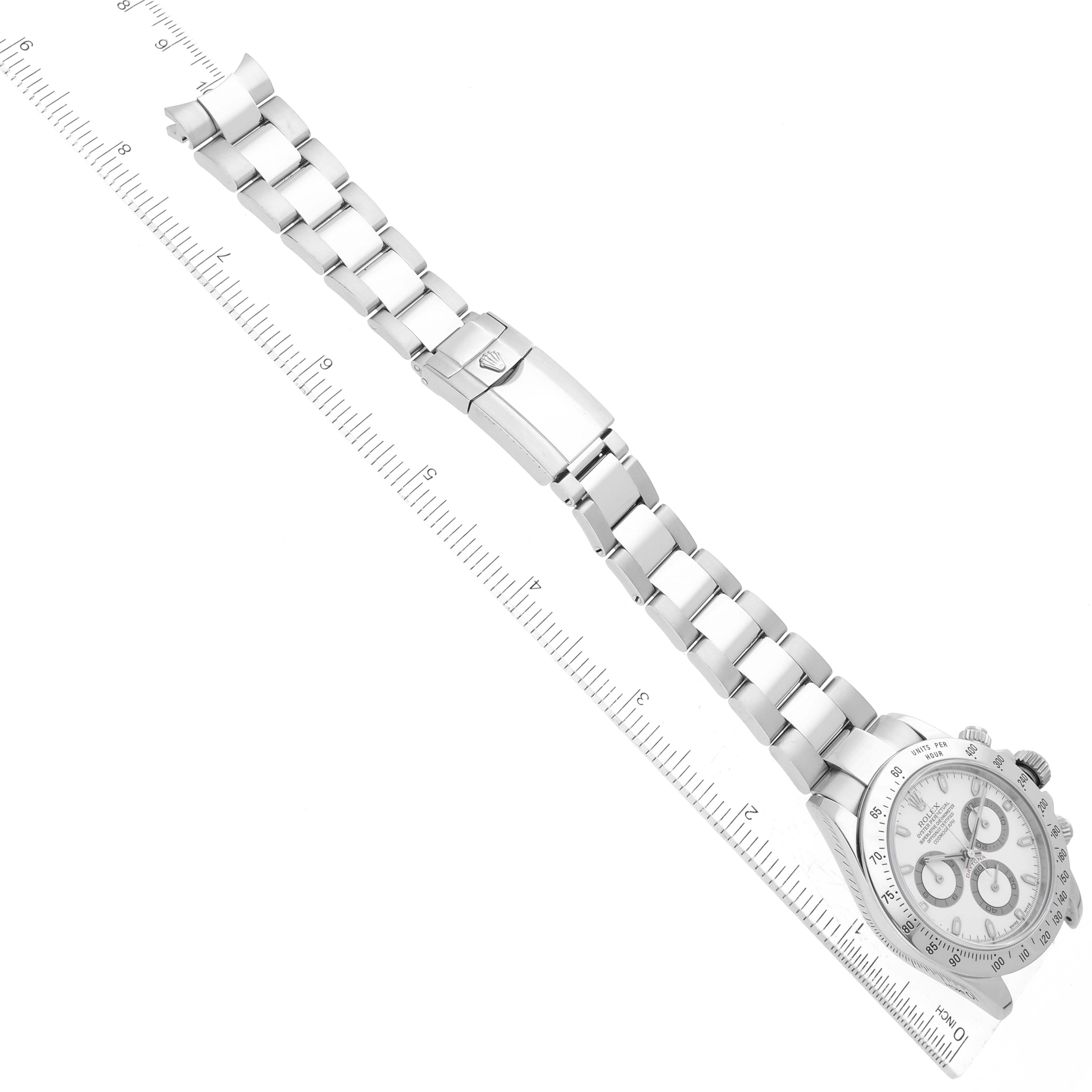 This image shows the Rolex Daytona 116520 Men's Stainless Steel White Dial 116520 Men's Stainless Steel White Dial watch laid flat with its bracelet extended adjacent to a ruler for measurement.