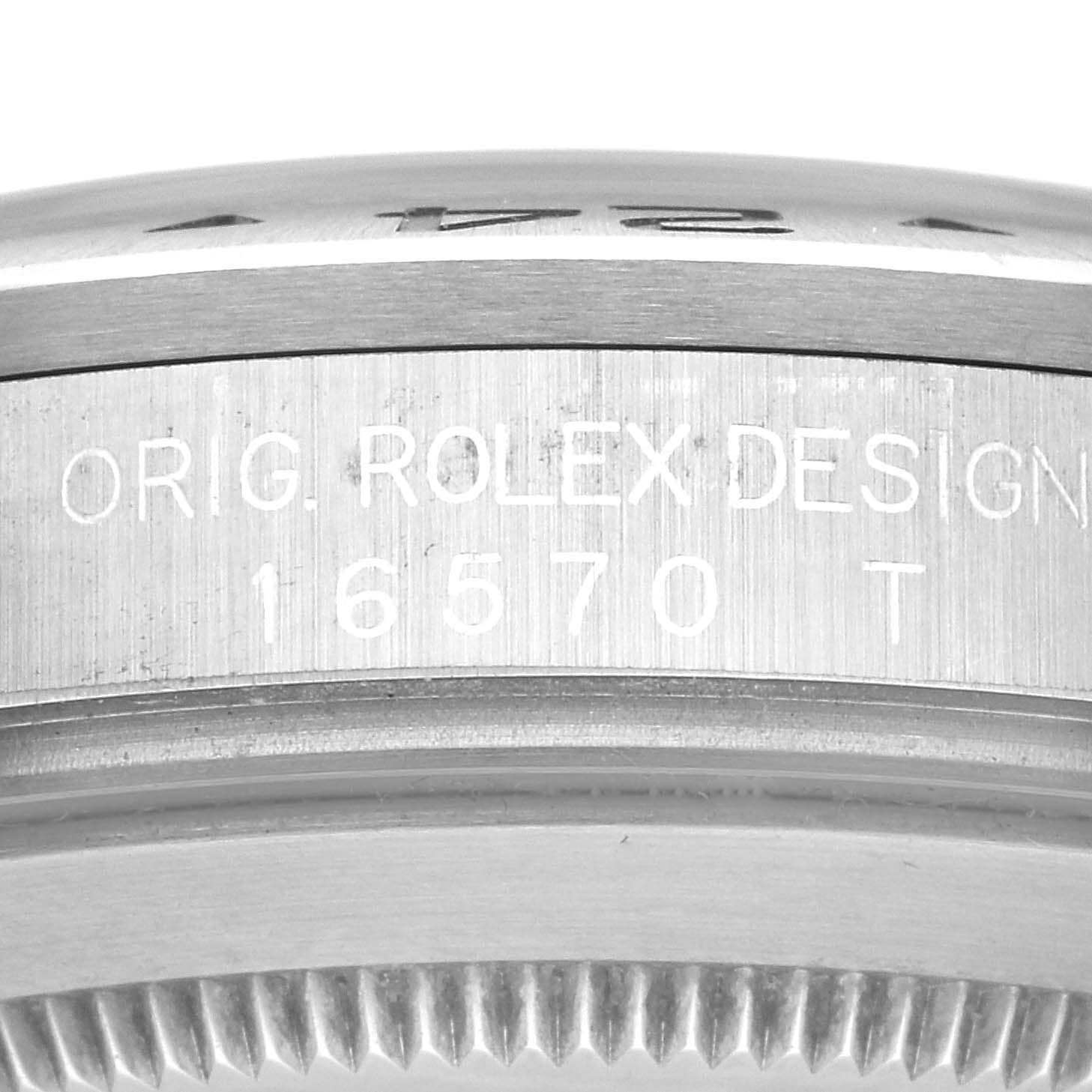 This image shows a close-up of the side of the bezel and case of the Rolex Explorer 16570 Men
s Stainless Steel Black Dial 16570 Men
s Stainless Steel Black Dial model, featuring the "ORIG. ROLEX DESIGN 16570 T" engraving.