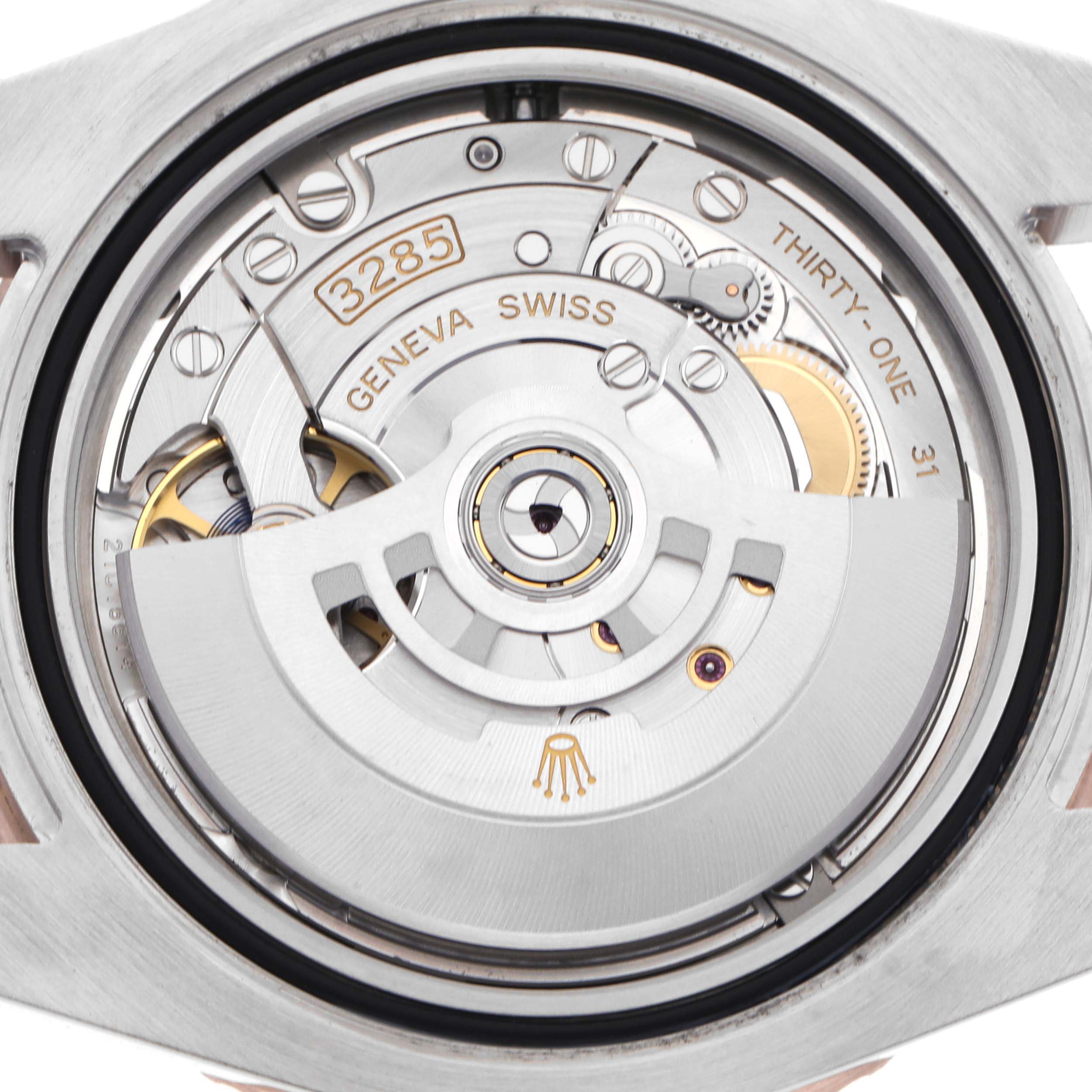 The image shows the movement of a Rolex GMT-Master 126711CHNR Men
s Steel and Gold (two tone) Black Dial 126711CHNR Men
s Steel and Gold (two tone) Black Dial, viewed from the back, revealing intricate gears and inscriptions.