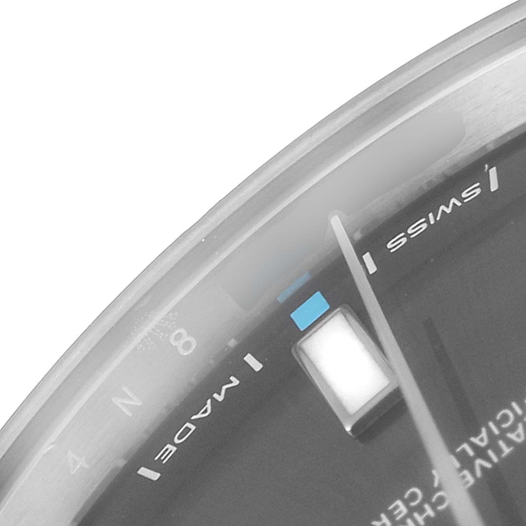 This image shows a close-up of the dial and part of the bezel of a Rolex Oyster Perpetual 114300 Men's Stainless Steel Silver Dial 114300 Men's Stainless Steel Silver Dial watch.