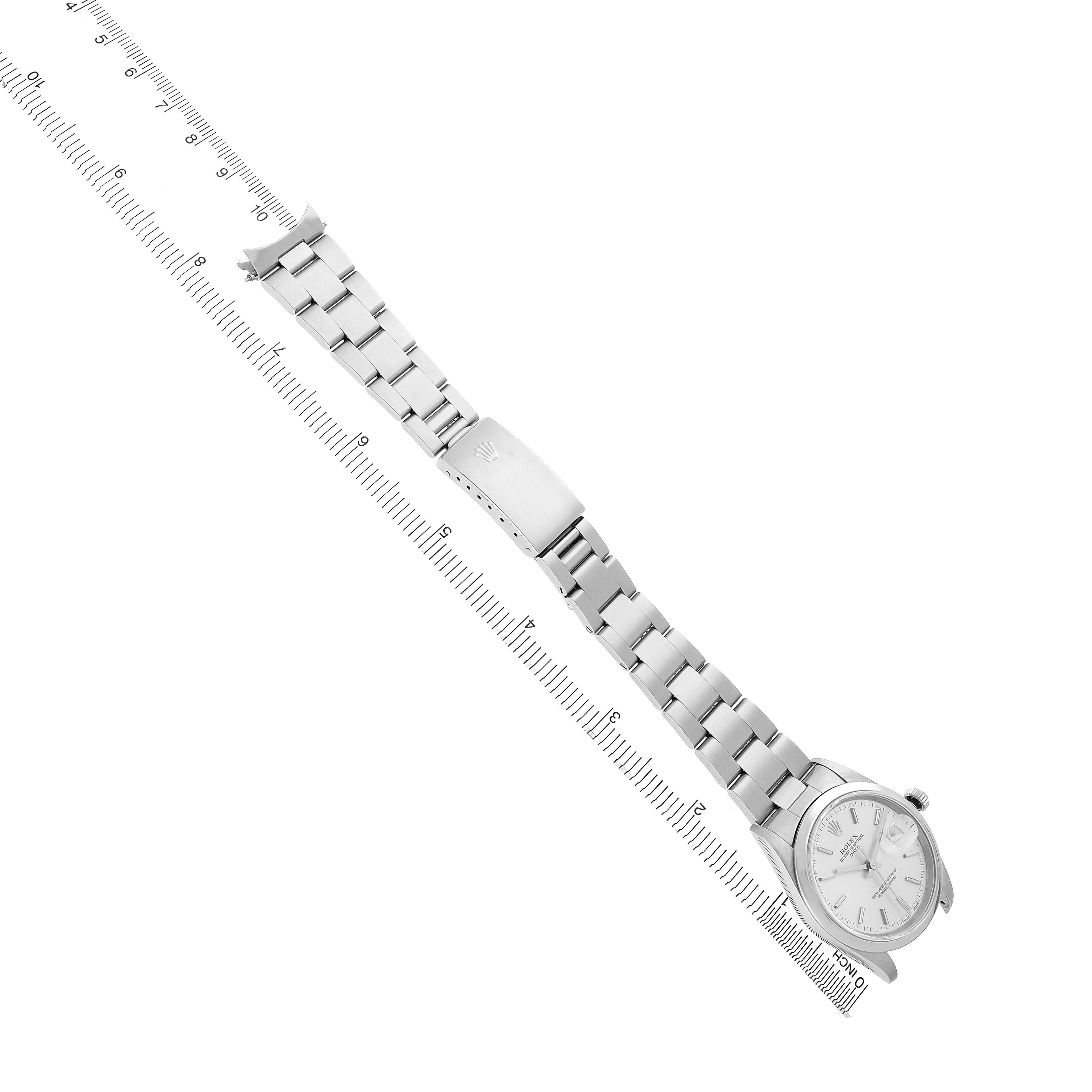 The image shows a Rolex Oyster Perpetual 15200 Men's Stainless Steel Silver Dial watch laid flat, displaying the face, band, and clasp alongside a measuring scale.