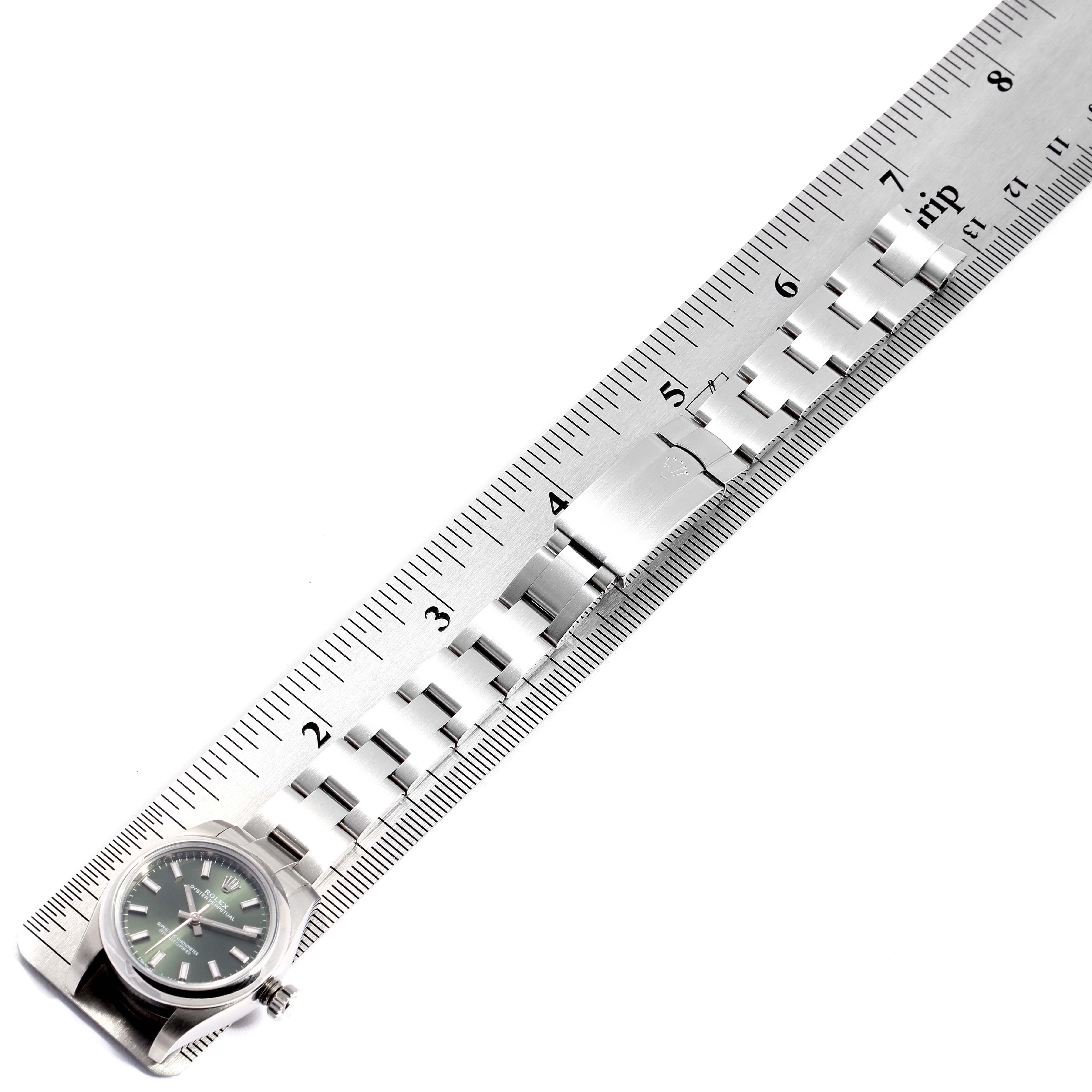 The image shows the Rolex Oyster Perpetual 176200 Women's Stainless Steel Green Dial 176200 Women's Stainless Steel Green Dial watch laid flat along a ruler, displaying its watch face and metal bracelet.